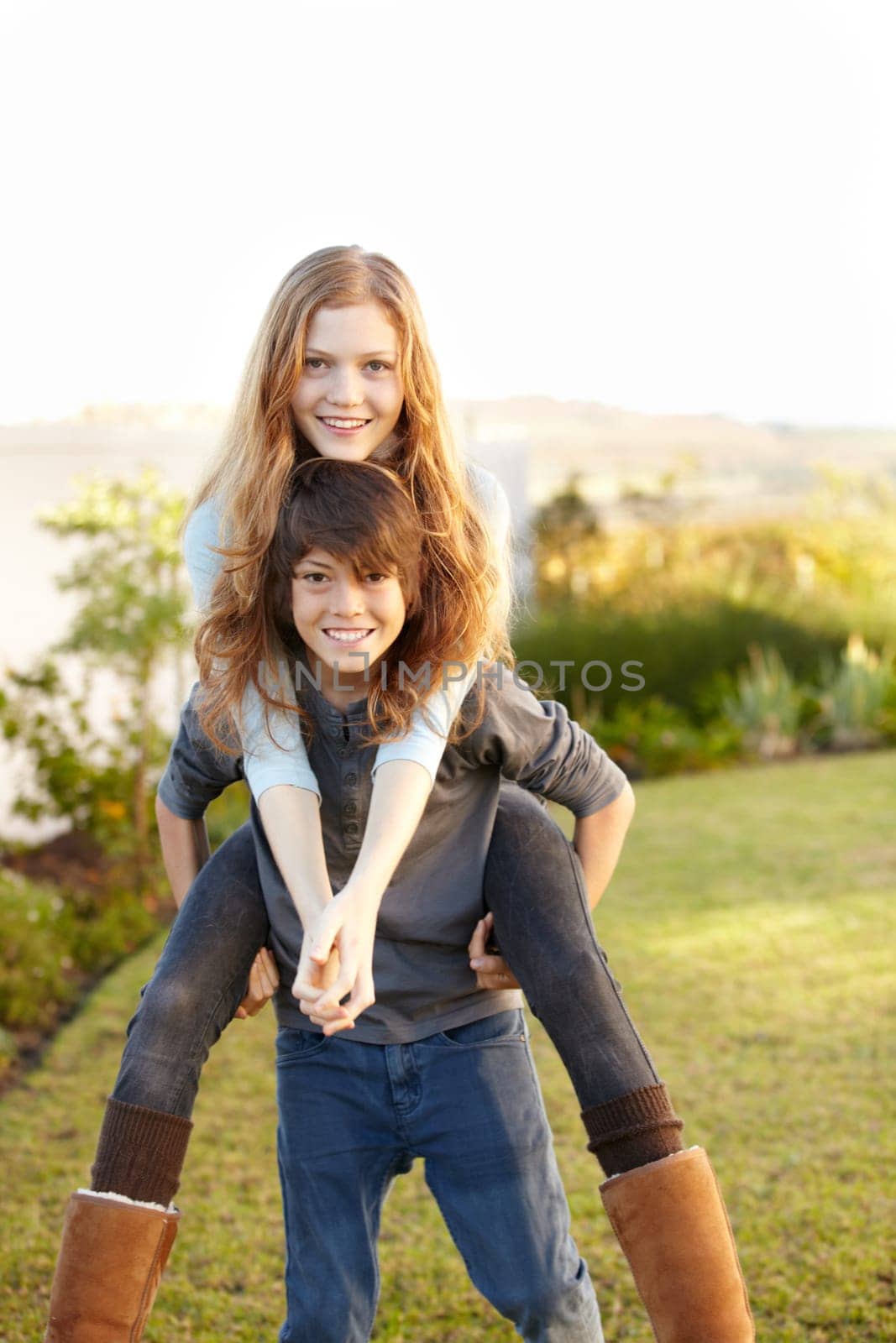 Boy, girl and portrait with piggy ride in the outdoor with happiness or playful summer. Happy, brother and embrace sister in garden with hug or back for bond or love with sunshine on weekend