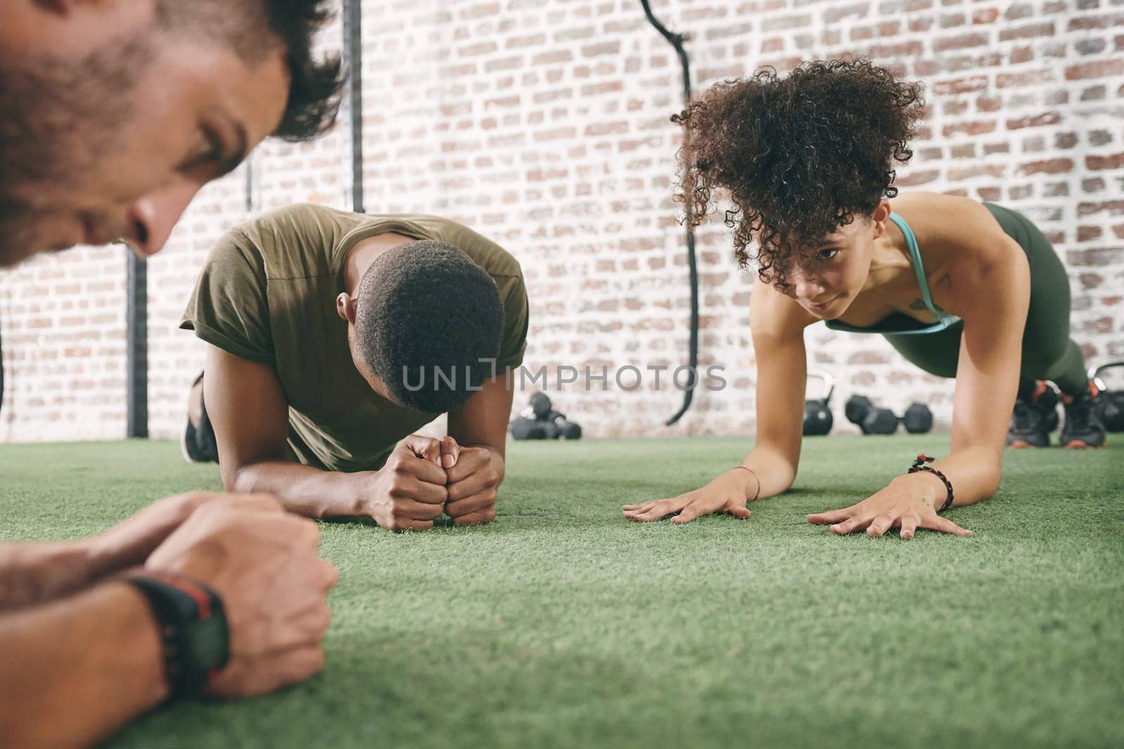 Determine your priorities and focus on them. a fitness group planking while working out at the gym