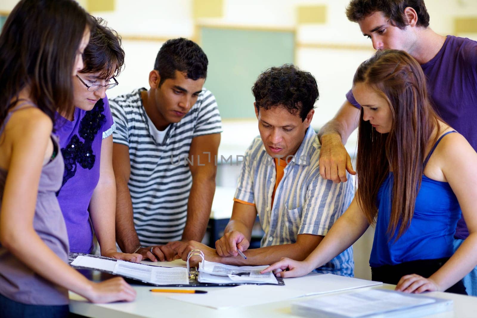 Education, university and a teacher with his students in the class for lecture or group study hall session. Learning, scholarship and friends in college with a male professor for exam preparation.