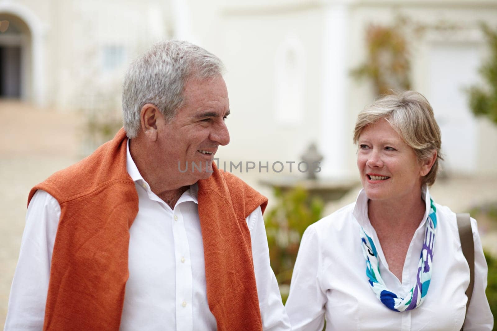 Smile, conversation and a senior couple in the city for a retirement holiday, travel and happiness. Happy, love and an elderly man and woman walking in an old town or hotel during a vacation together.