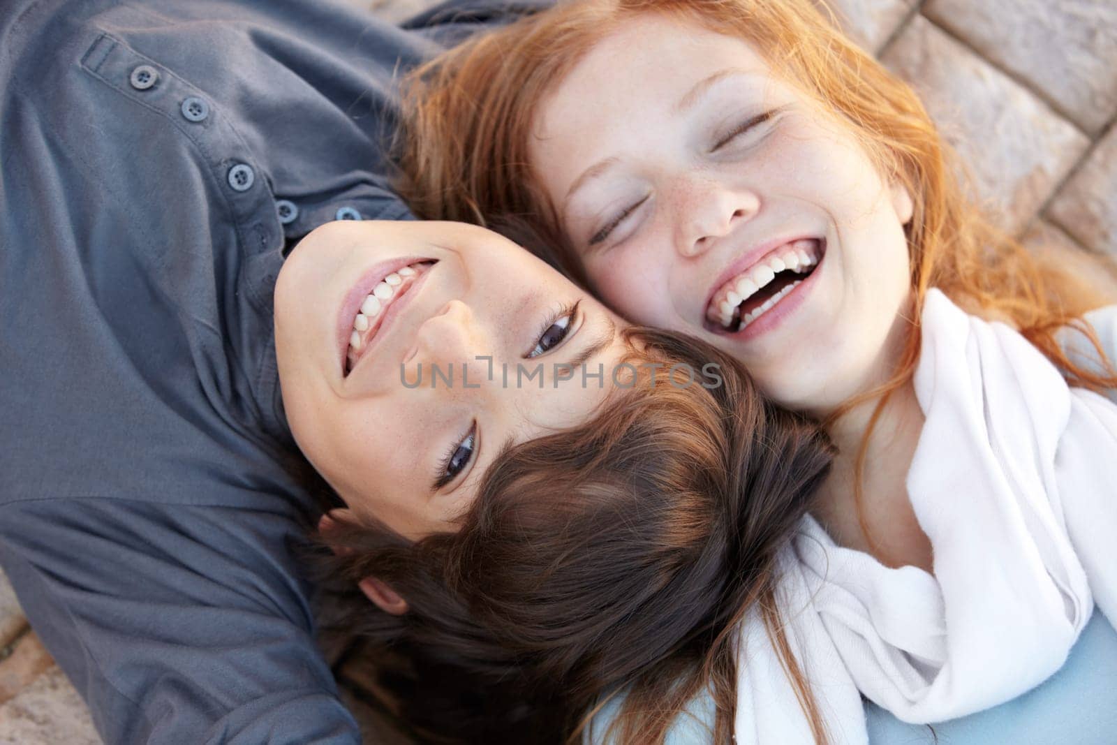 Portrait, laughing and above of friends in nature for love, bonding and happiness. Smile, care and a boy, girl or sibling children on the ground together for a funny joke, friendship or playful.