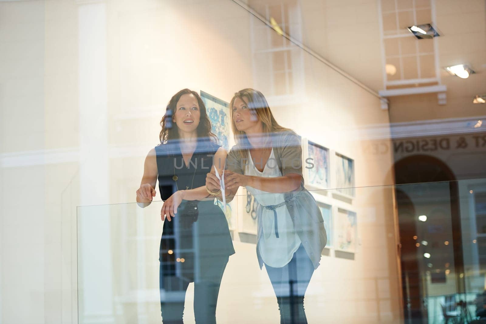Women, friends together and exhibition at gallery, conversation and culture appreciation. Woman, art critic partnership and looking in museum with talk, lifestyle and ideas by window with reflection.
