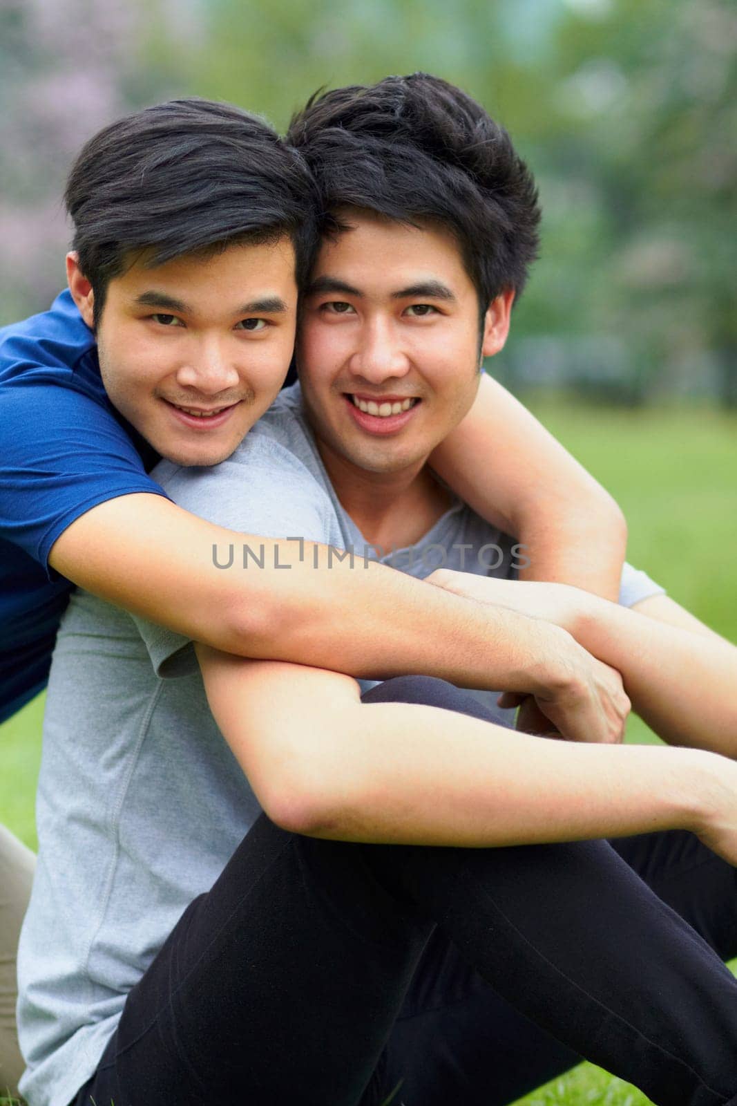 Asian men, gay couple and hug in park portrait, grass or garden with love, care and bonding in summer sunshine. Happy Japanese guy, romance or relax together on lawn with lgbtq, nature and holiday.