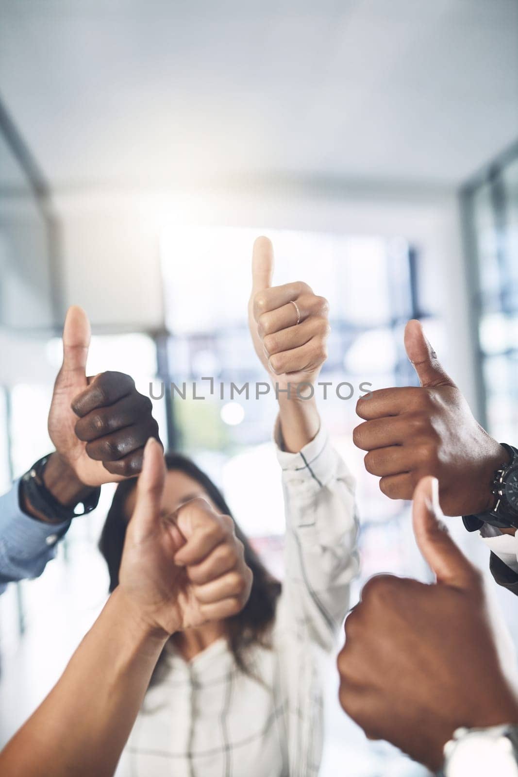 Teamwork allows you to produce the best work. Closeup shot of a group of businesspeople showing thumbs up in an office. by YuriArcurs