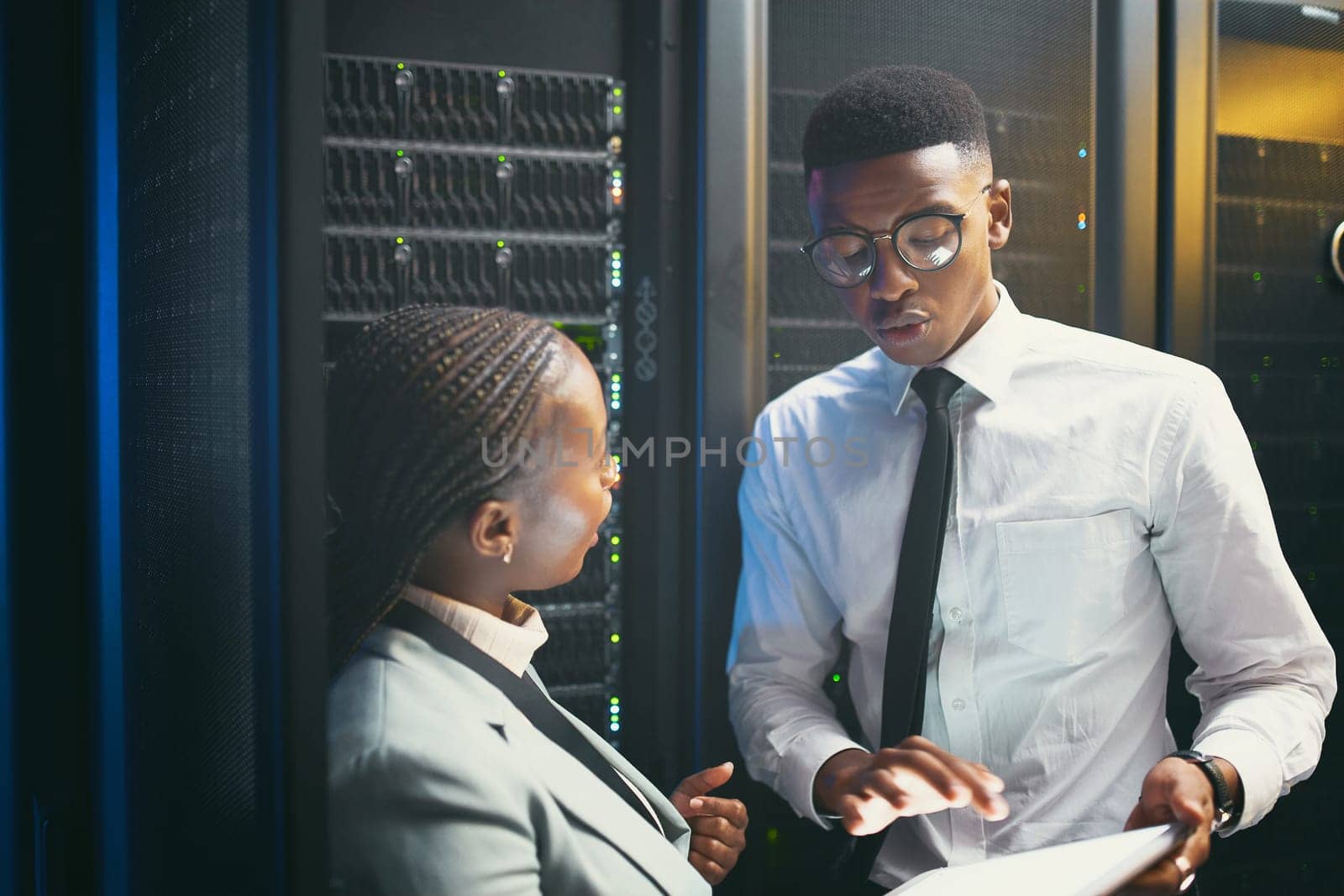 Were the only two who can solve technology issues. two young IT specialists standing in the server room and having a discussion while using a digital tablet