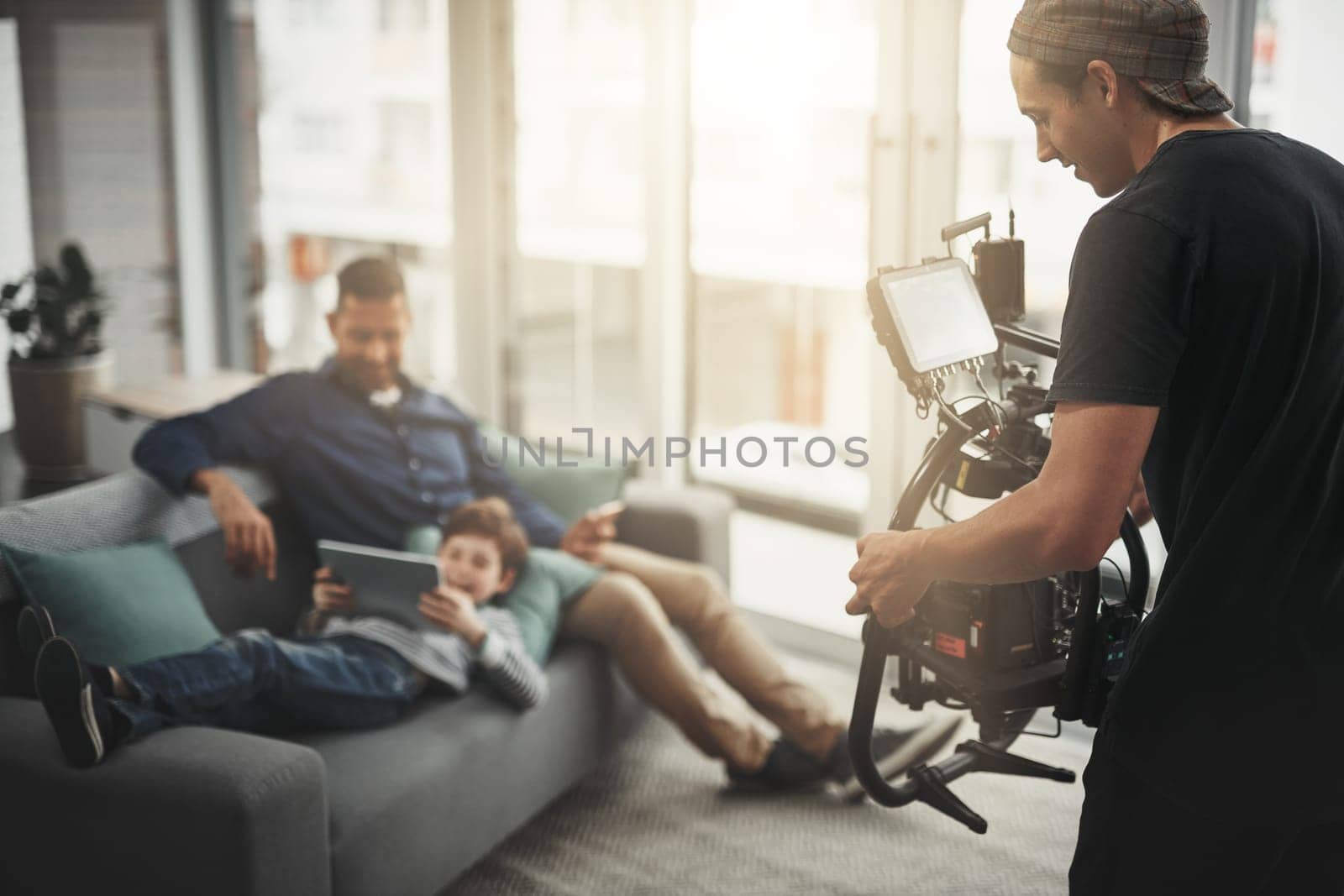 You guys are doing great. Behind the scenes shot of a camera operator shooting a scene with a state of the art camera inside of a studio during the day