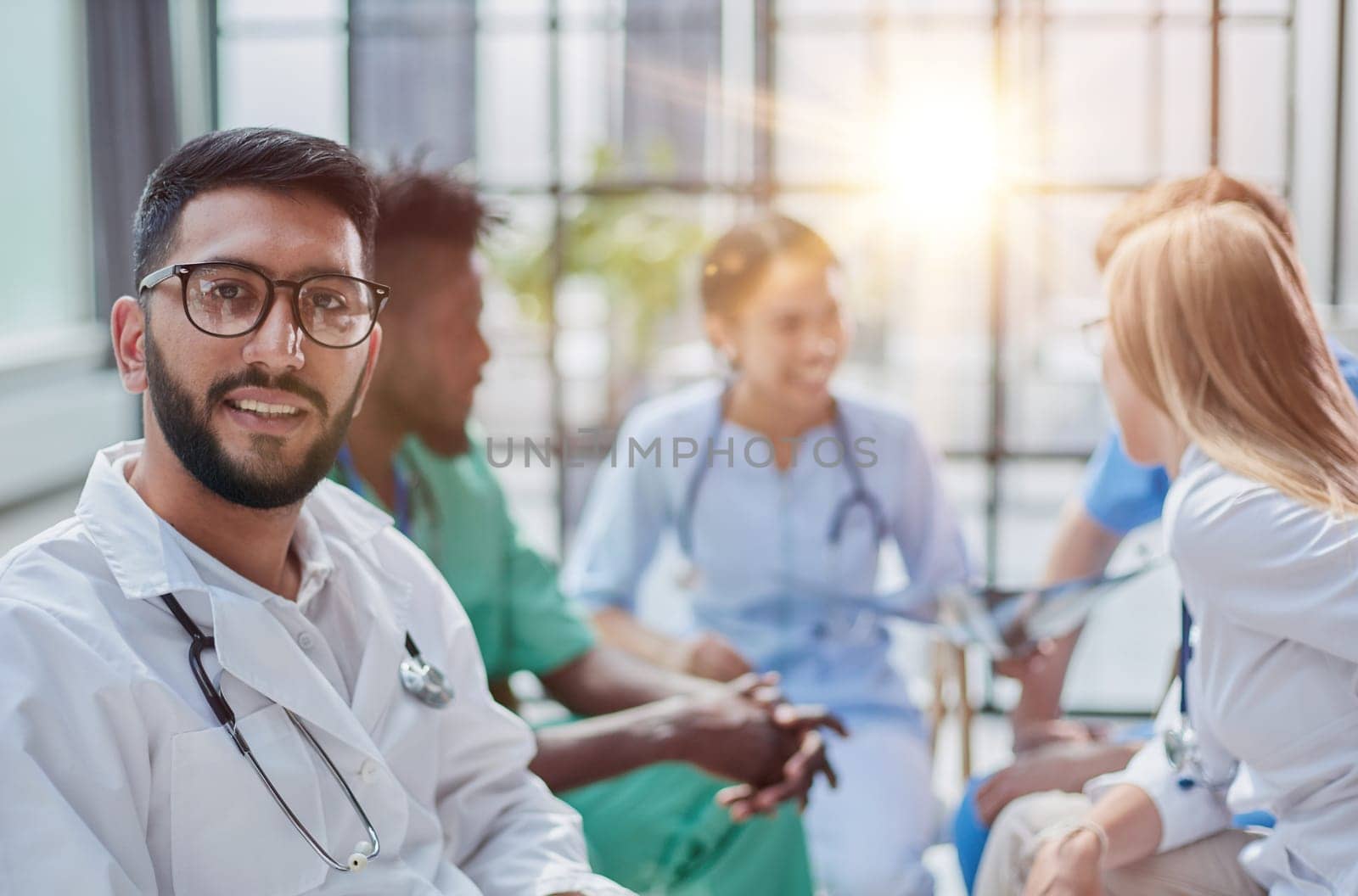 a young doctor in glasses looks at the camera