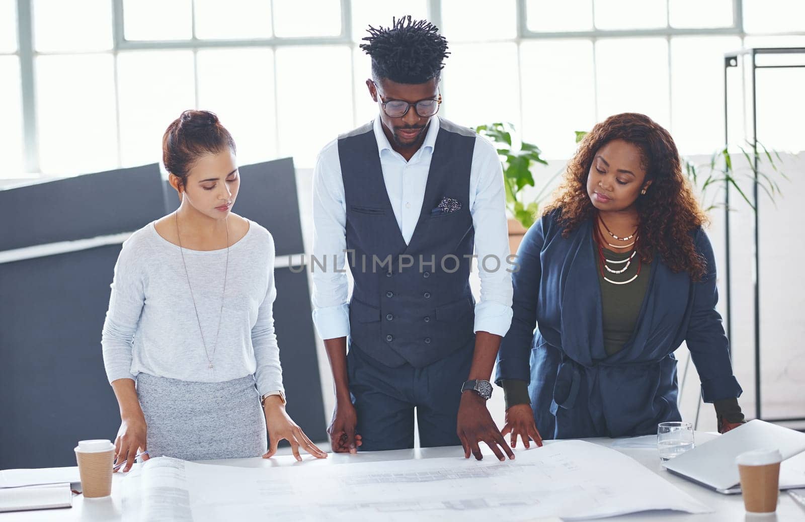 They are the best in the business. a team of professionals working on blueprints in an office