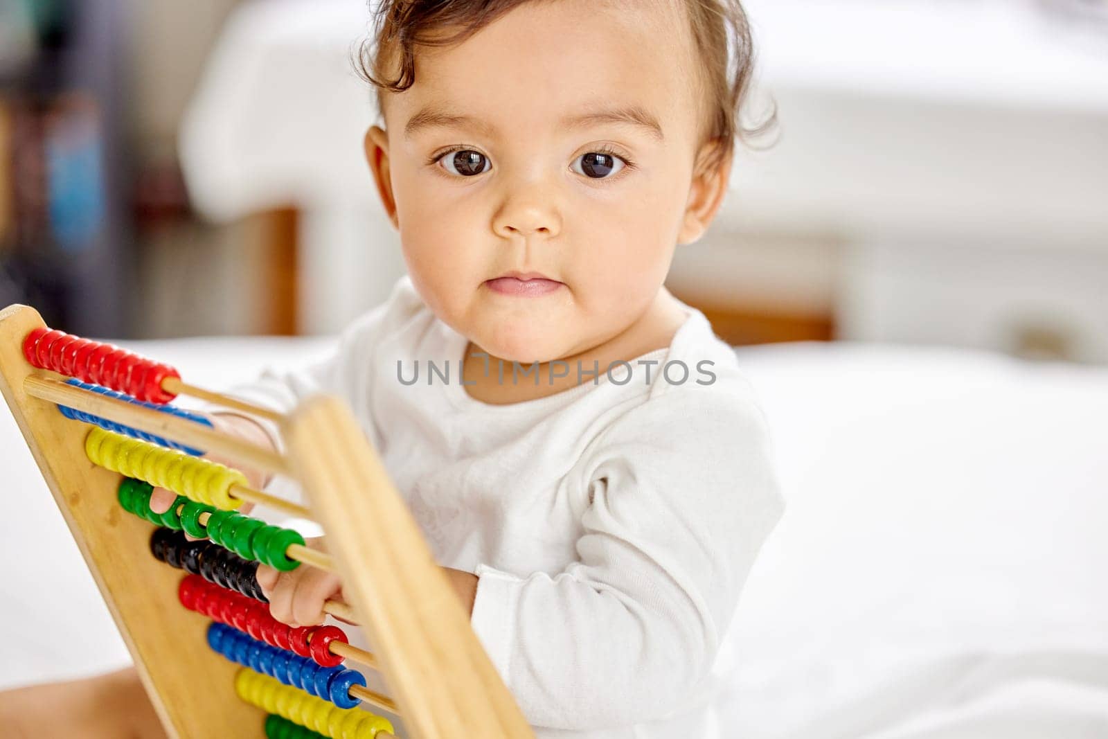 Abacus, bedroom and baby play with toy for learning, child development and motor skills. Family home, newborn and face of adorable child with educational toys, counting beads and playing in bed.