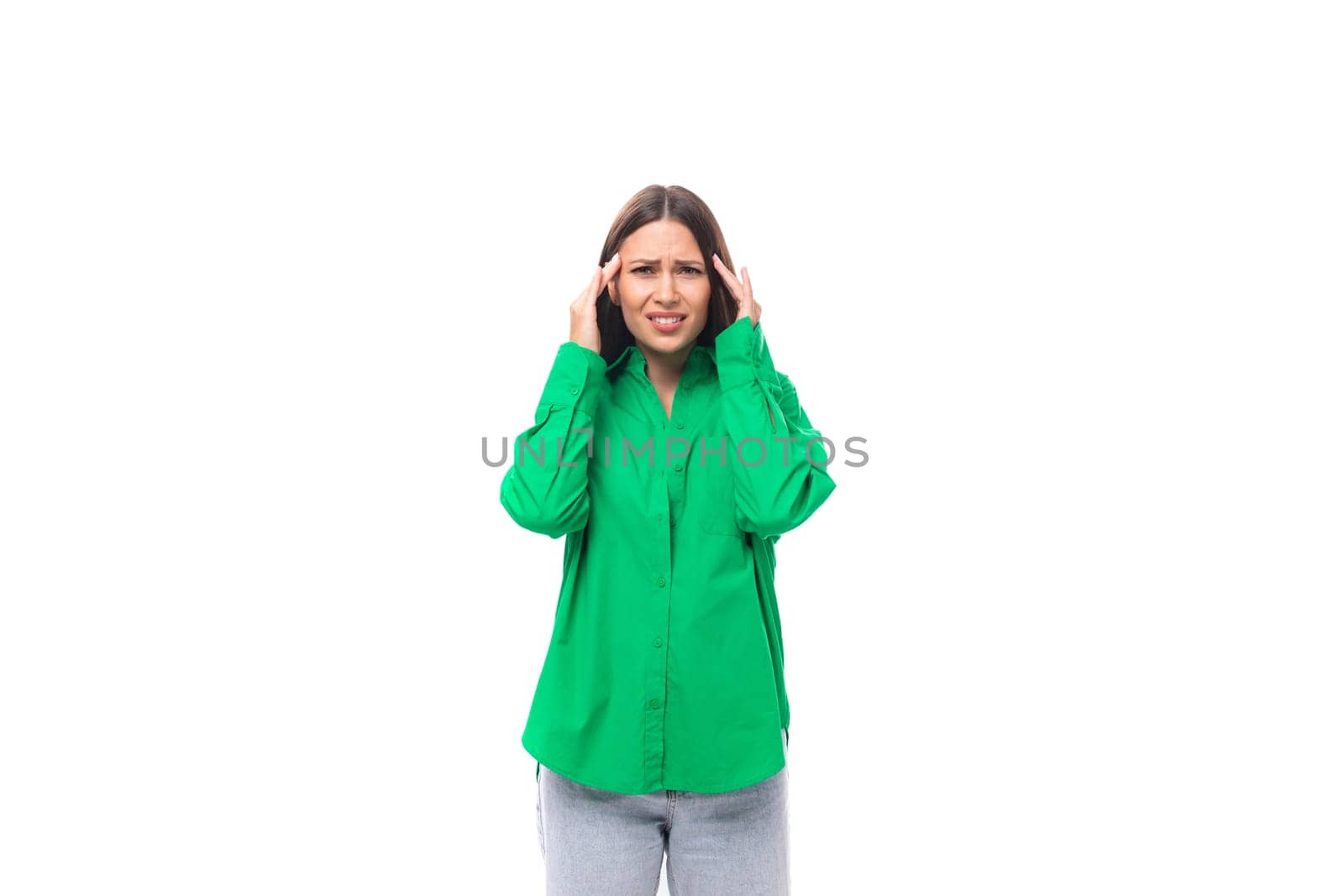 attractive confused young caucasian brunette lady with make-up dressed in an elegant green shirt on a white background with copy space by TRMK