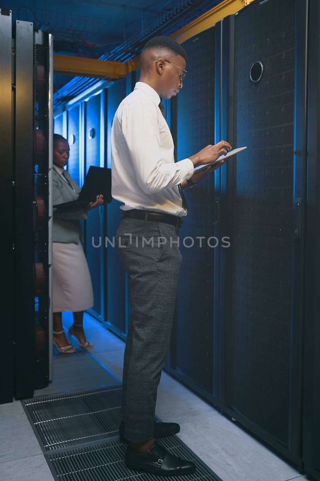 Strengthening the firewall. two young IT specialists standing together in the server room and using technology