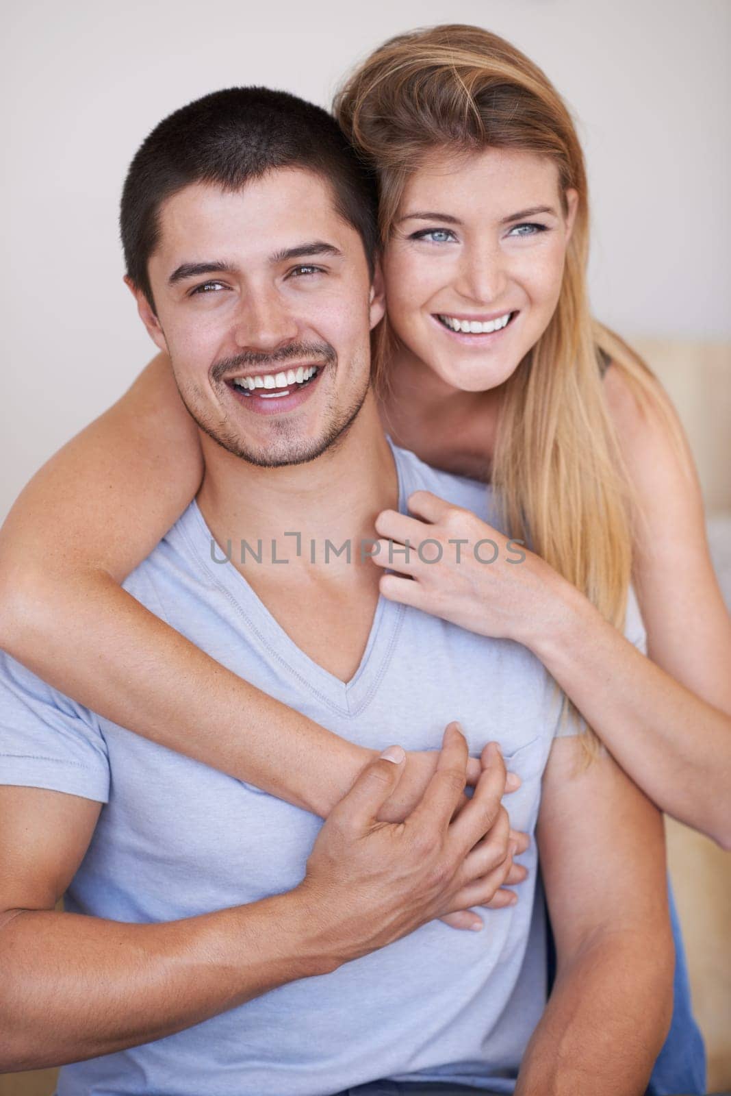 In love and feeling great. Attractive young couple relaxing together happily at home. by YuriArcurs