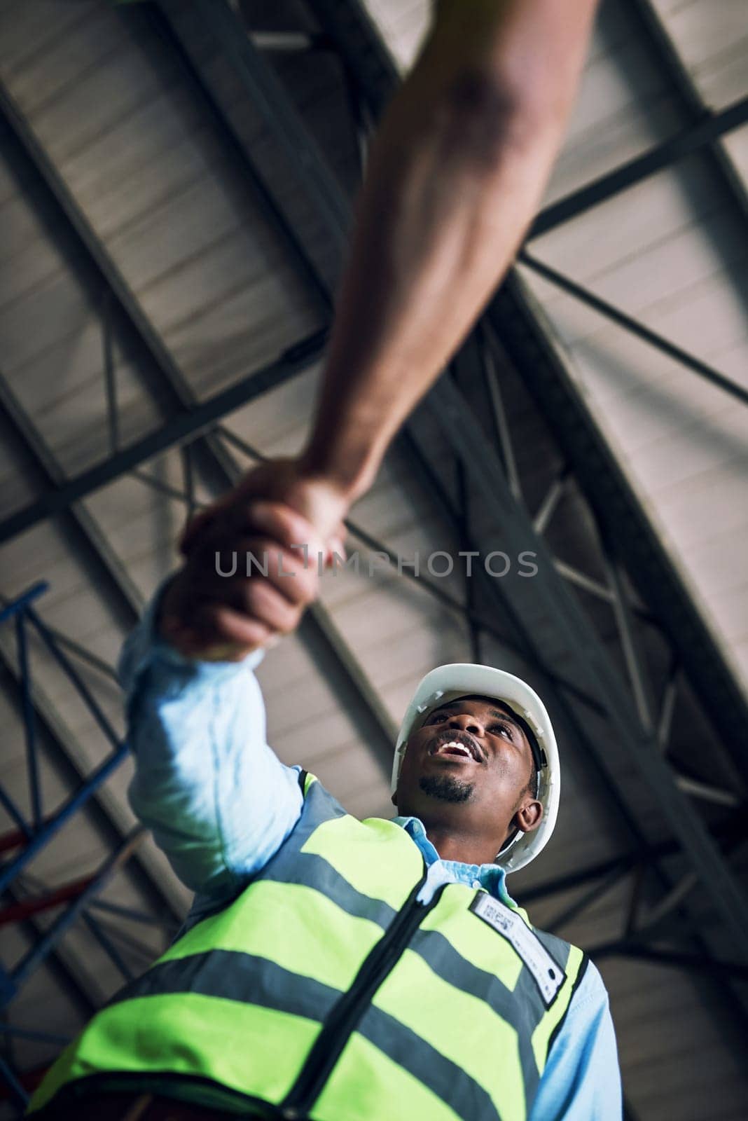 Black man, architect and handshake for construction, building or hiring in teamwork partnership on site. Low angle of African male engineer shaking hands in recruiting, architecture agreement or deal by YuriArcurs