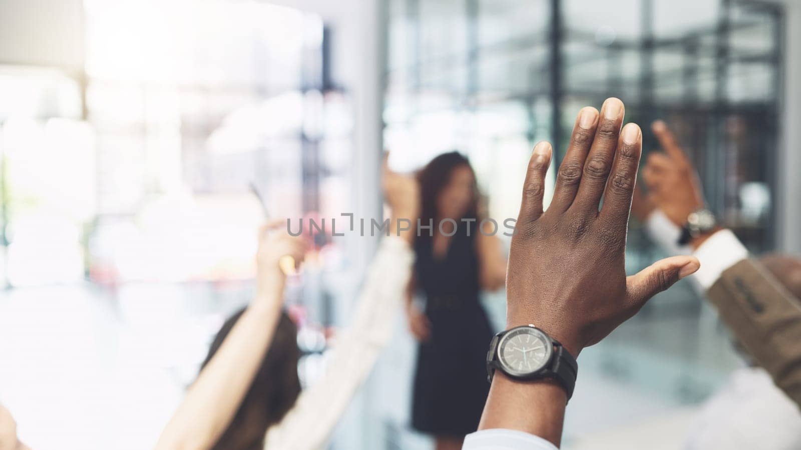 Ask as many questions as you need. Closeup shot of a group of businesspeople raising their hands during a presentation in an office. by YuriArcurs