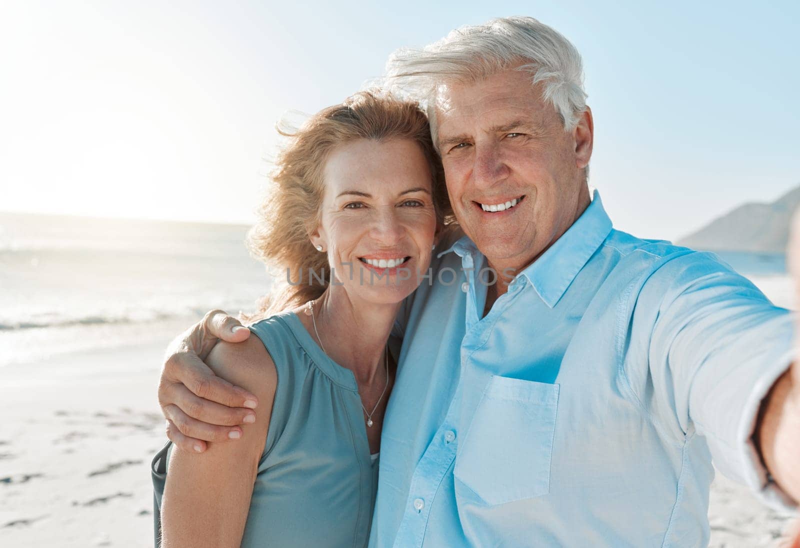 Senior, couple and selfie at the beach with portrait for happiness on holiday for the weekend. Mature, woman and man hug at the ocean for closeup and smile in the outdoor on vacation for retirement. by YuriArcurs