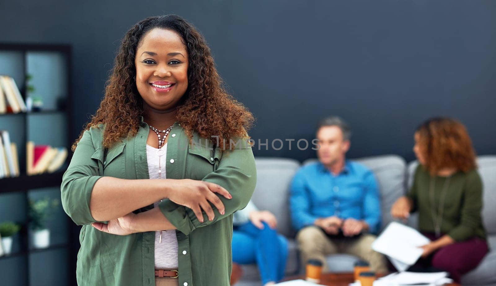 She runs the show around here. Portrait of a confident young businesswoman with her team blurred in the background