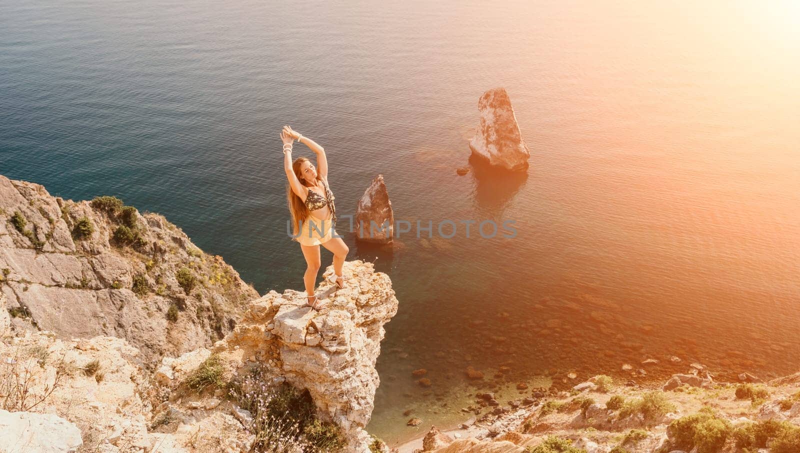 Woman travel sea. Happy tourist taking picture outdoors for memories. Woman traveler looks at the edge of the cliff on the sea bay of mountains, sharing travel adventure journey.