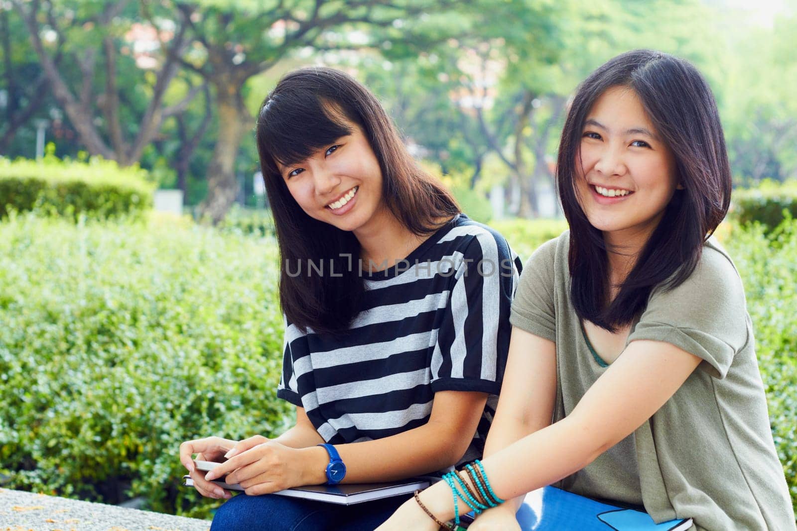 University, nature and portrait of girl friends with scholarship sitting outdoor on campus for education. Knowledge, smile and female college students in park for fresh air studying for test or exam
