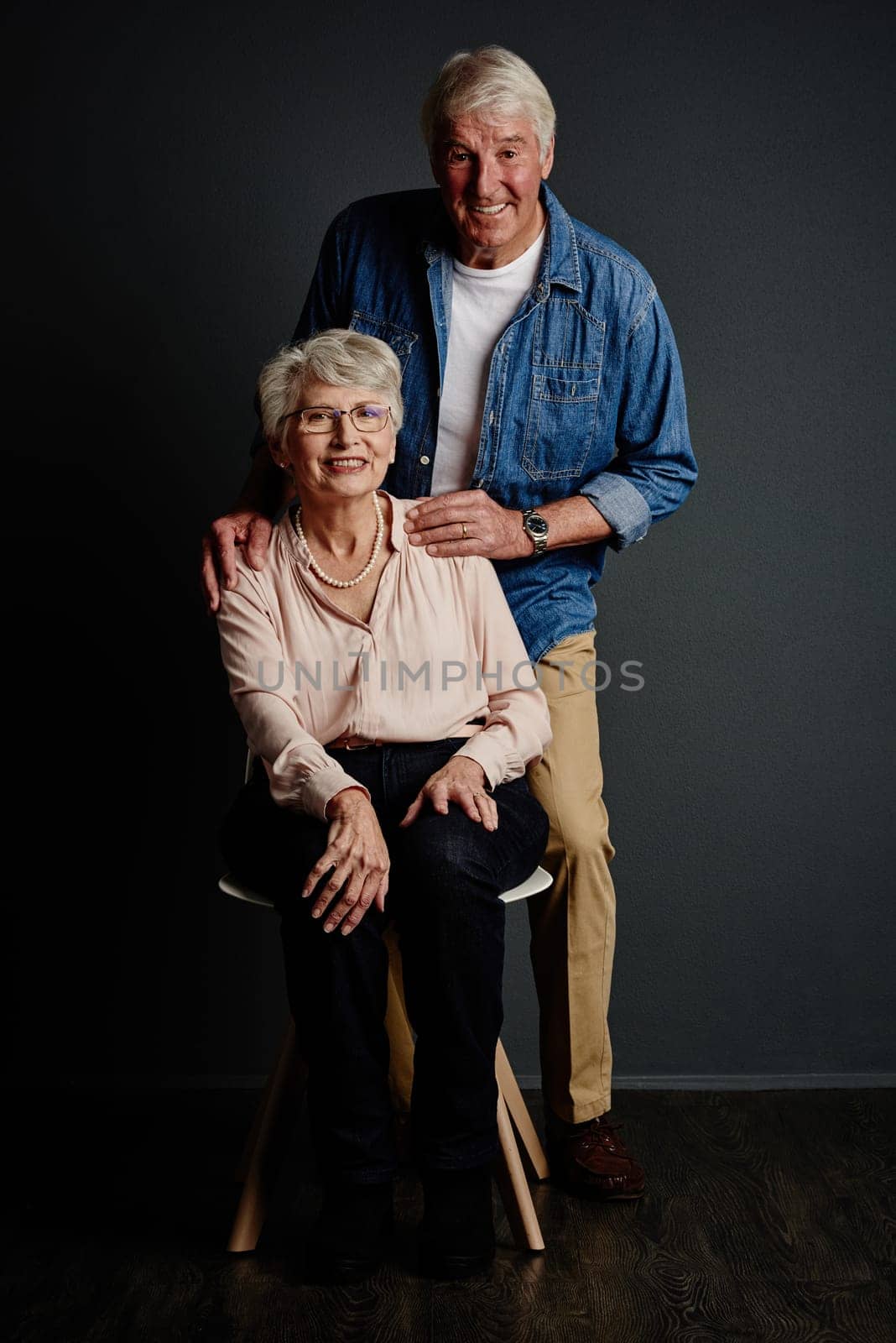 Me and her against the world. Studio portrait of an affectionate senior couple posing against a grey background. by YuriArcurs