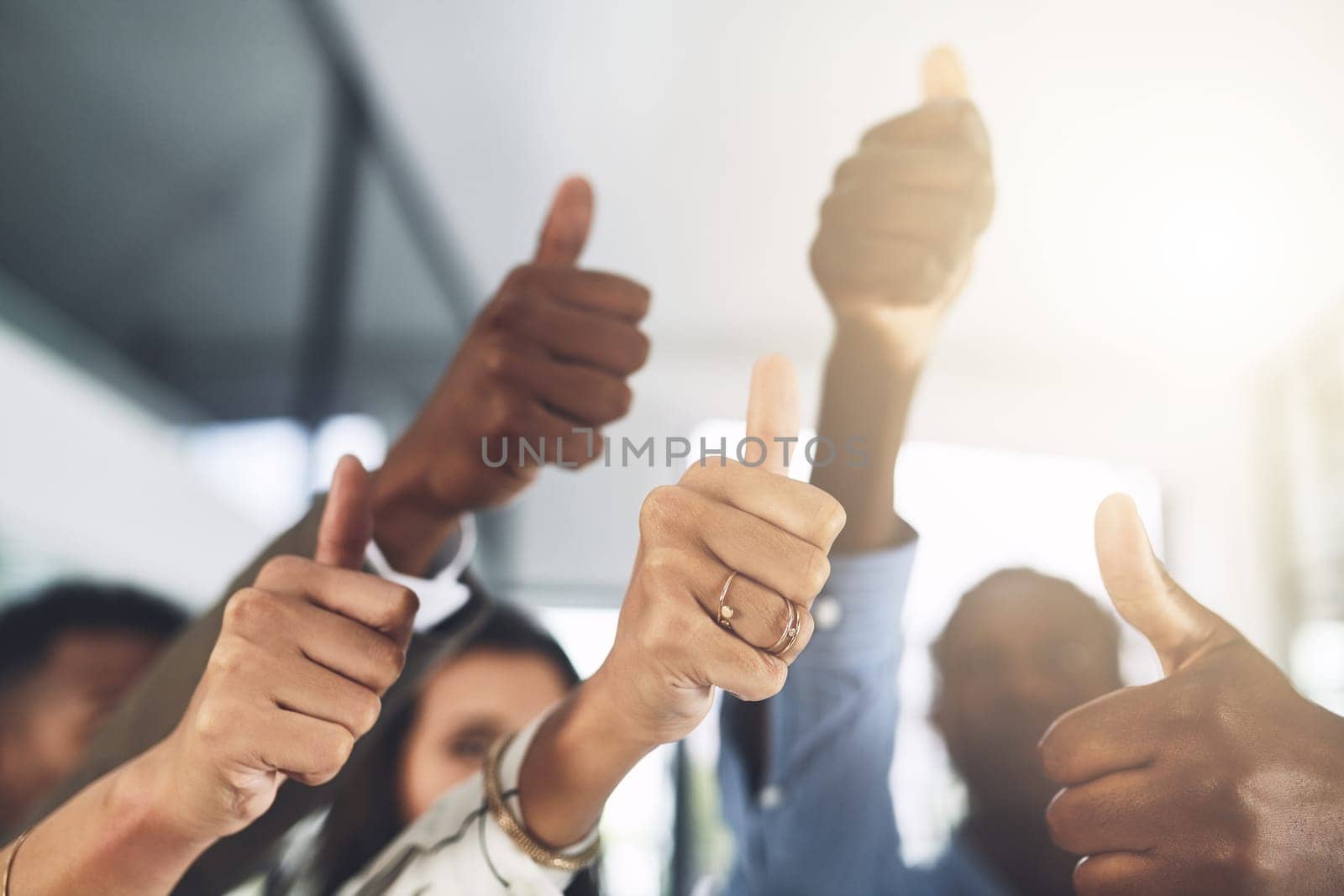 Wishing you all the best. Closeup shot of a group of businesspeople showing thumbs up in an office. by YuriArcurs