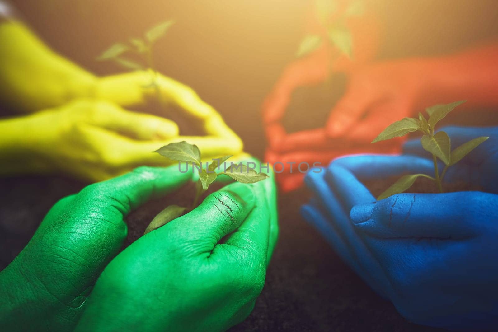 Lend nature your hands. unrecognizable people holding budding plants in their multi colored hands. by YuriArcurs