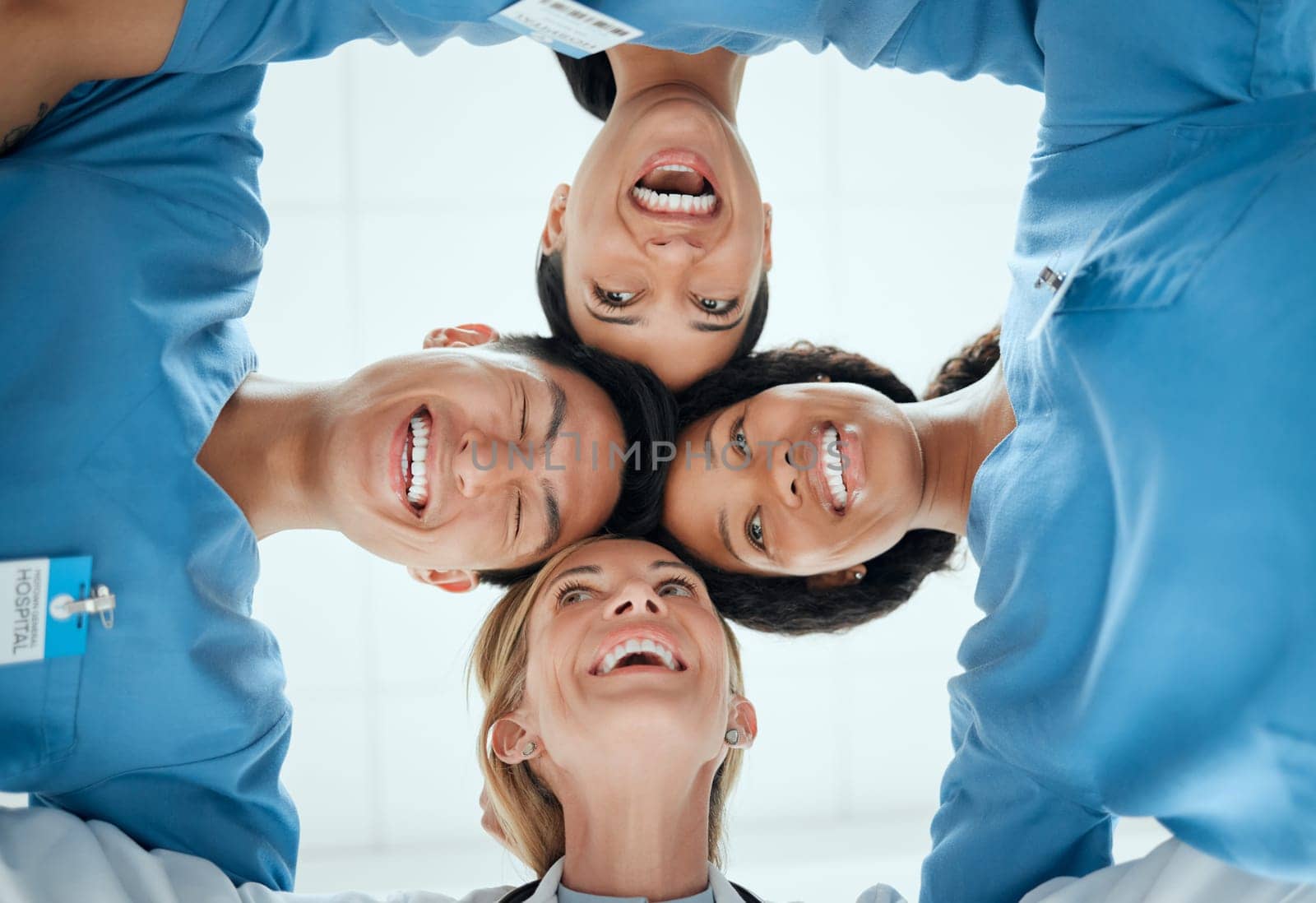 Smile, teamwork or faces of doctors in huddle laughing in collaboration together for healthcare goals. Low angle, funny team building or happy medical nurses with group support, motivation or mission.