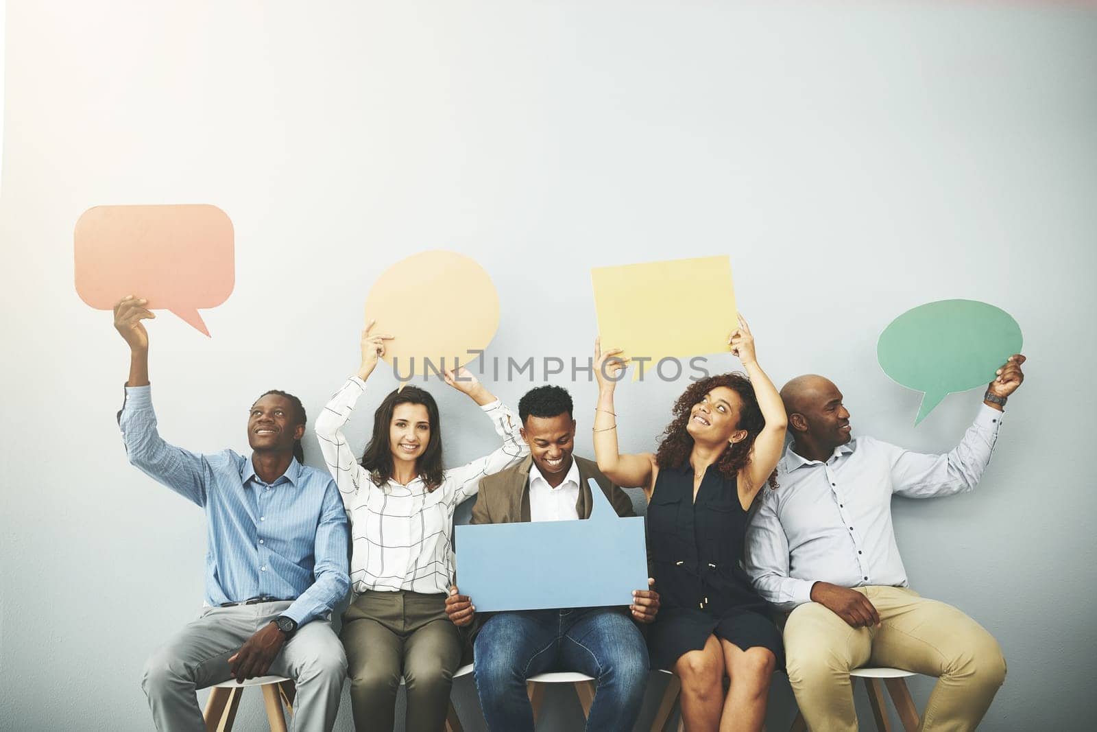 Your opinion matters. Studio shot of a group of businesspeople holding colorful speech bubbles in line against a gray background