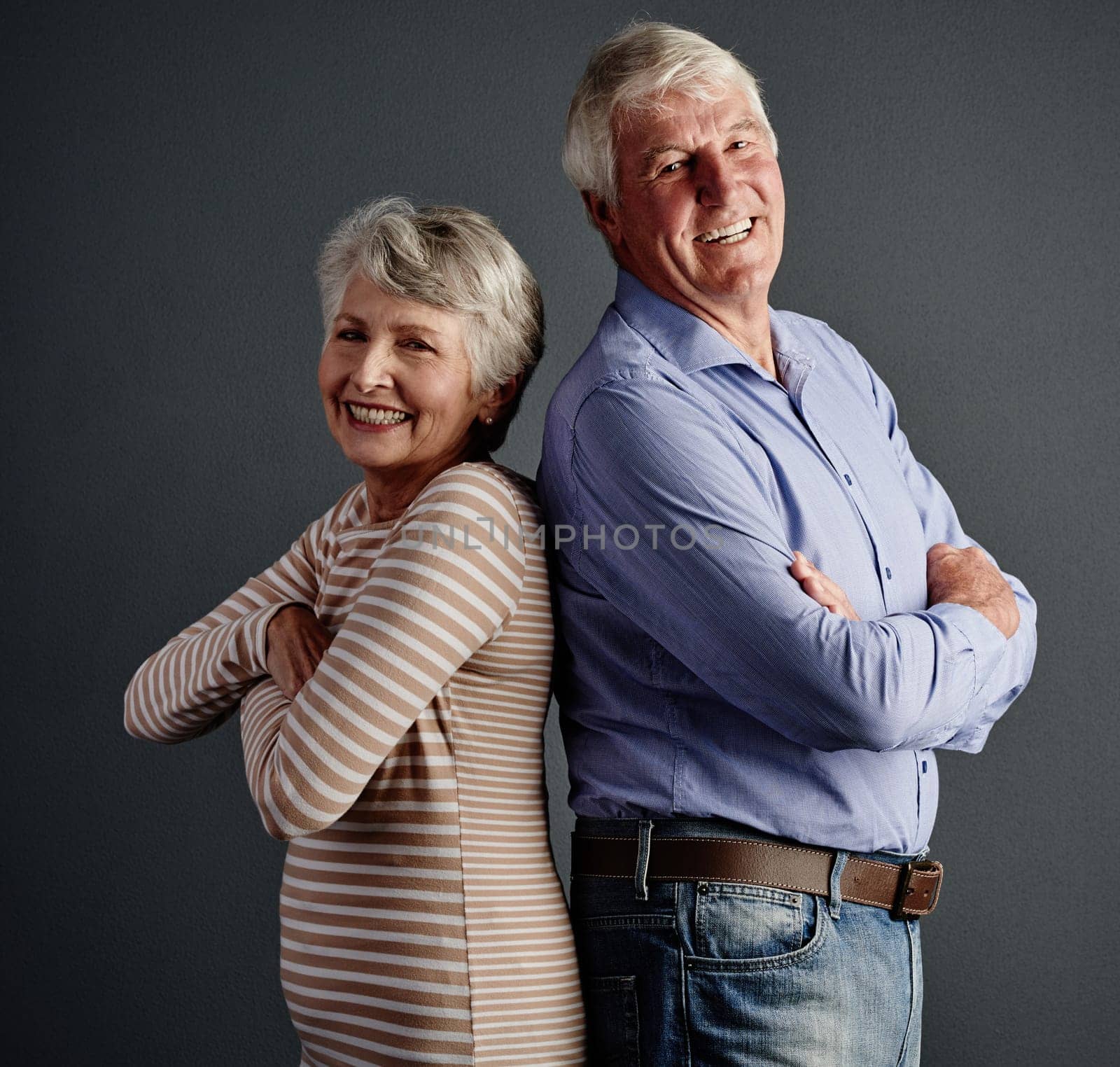 Ive got your back. Studio portrait of an affectionate senior couple posing against a grey background. by YuriArcurs