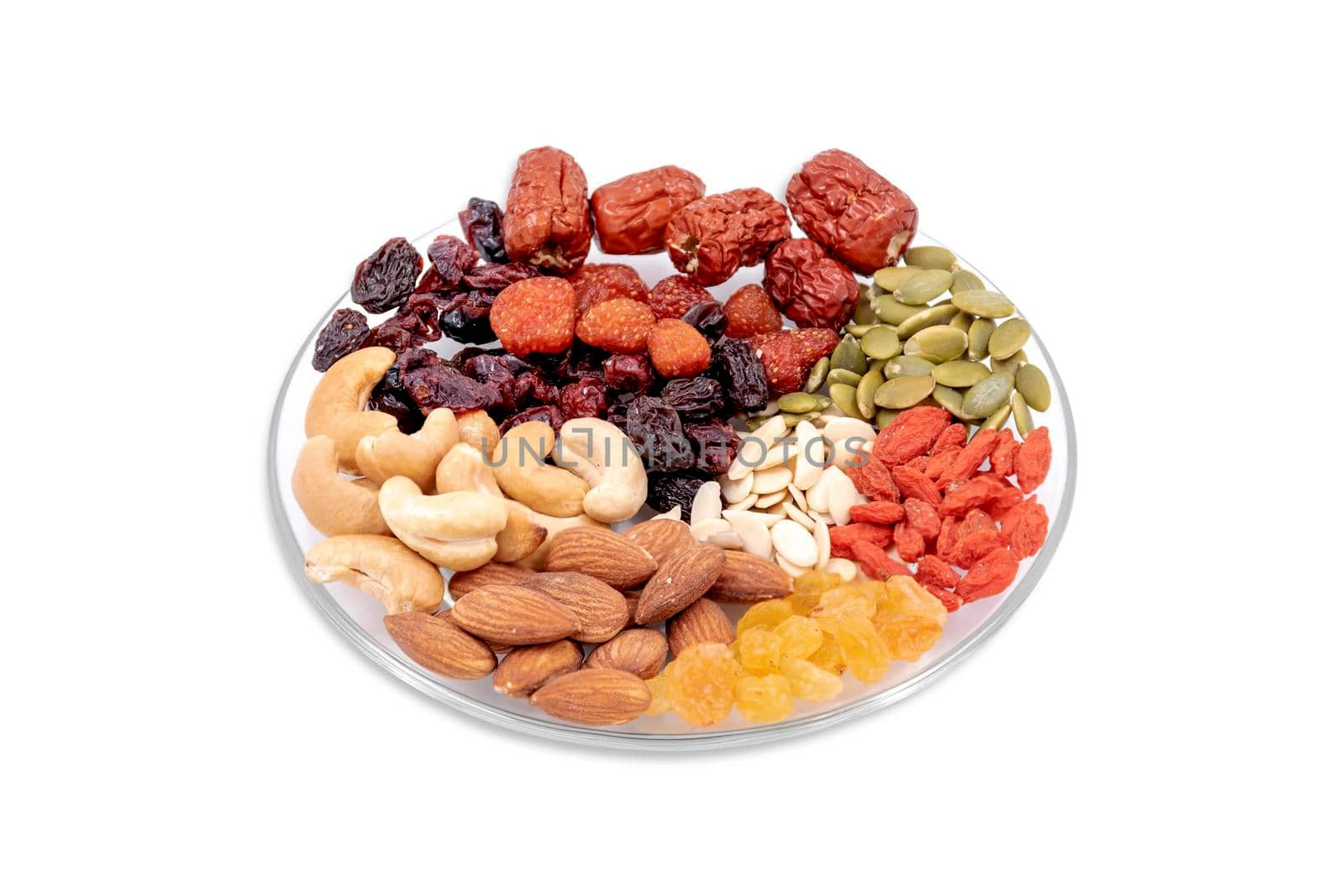 Group of whole grains and dried fruit in a glass plate isolated on white background.