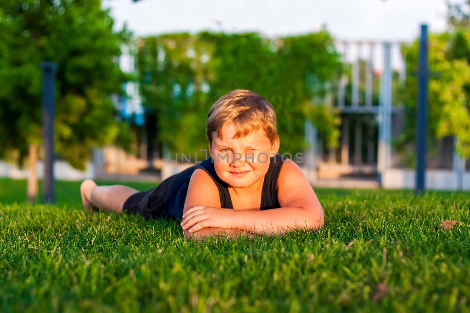 The child spends time in the park, he is very happy. Have fun and enjoy a summer day. Walking and recreation. Portrait of a happy child