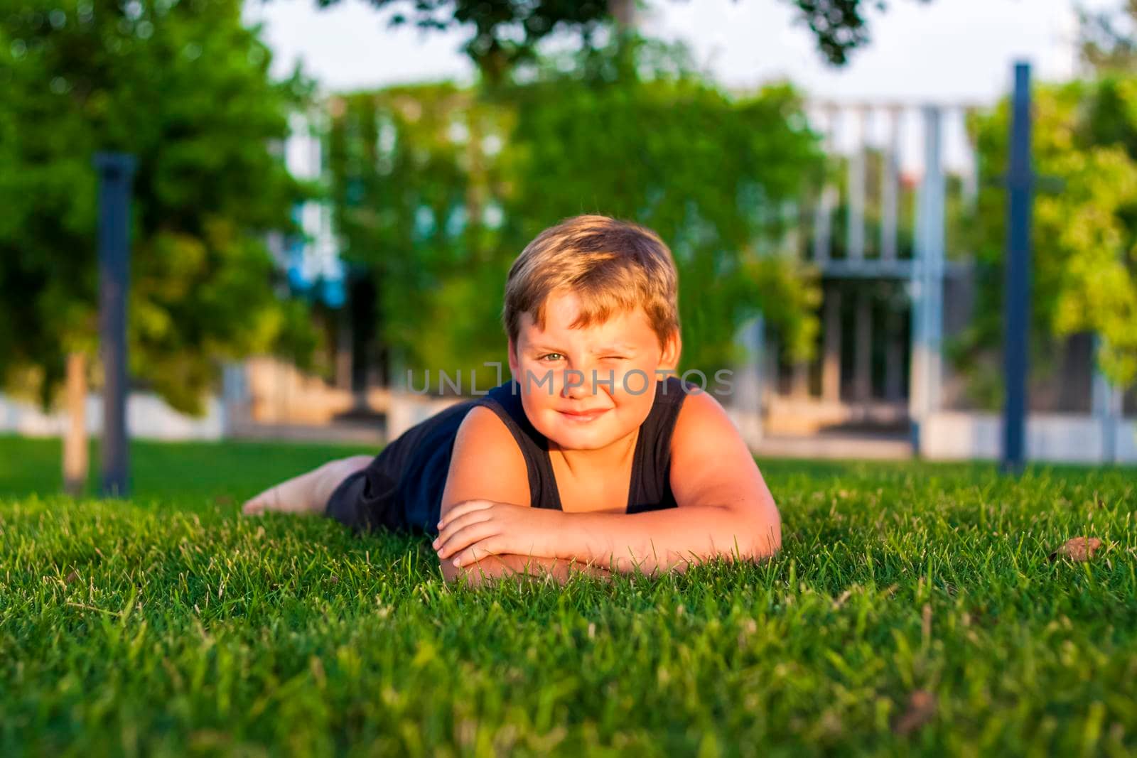 The child spends time in the park, he is very happy. Have fun and enjoy a summer day. Walking and recreation. Portrait of a happy child