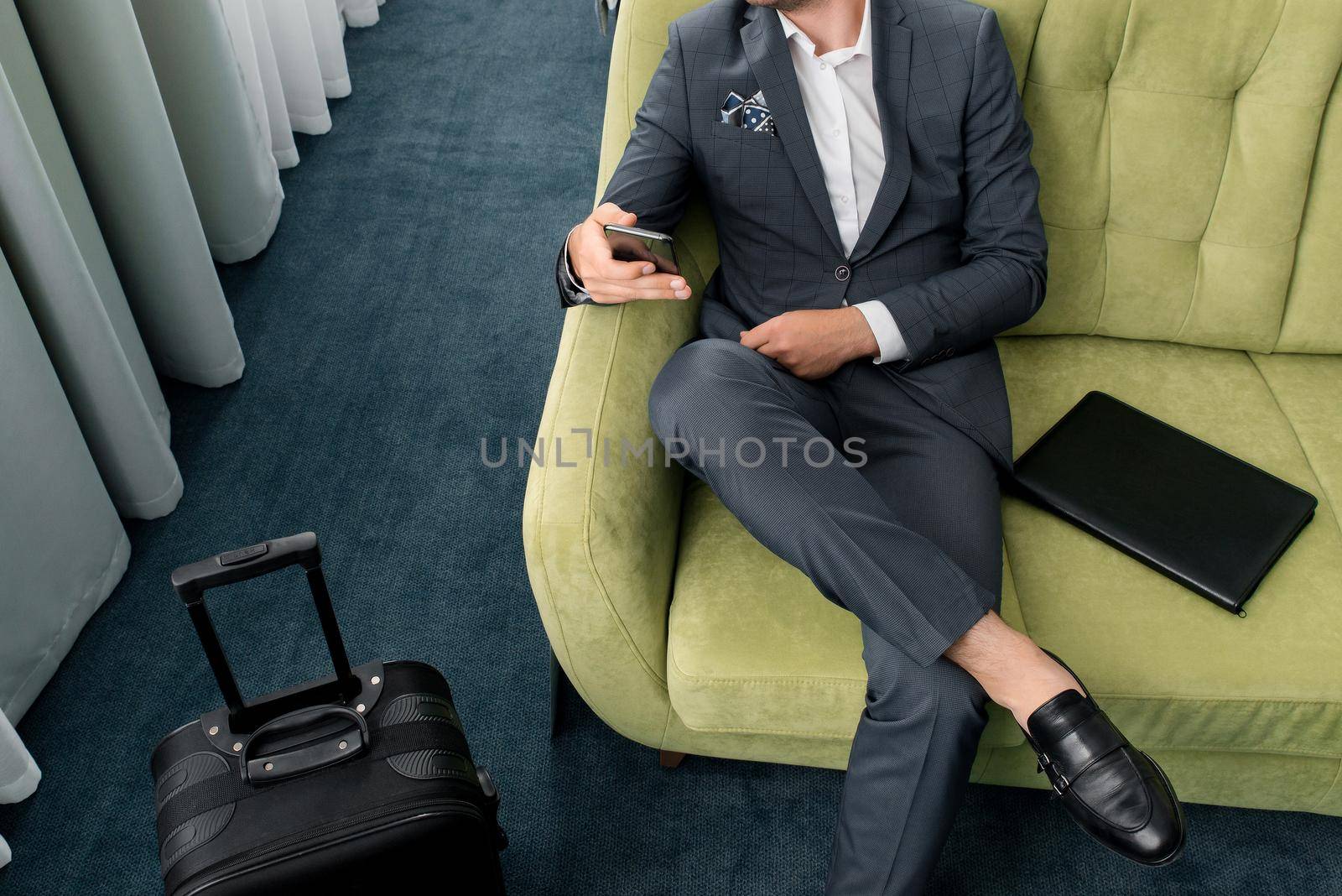 Young businessman working from a hotel room with his mobile phone