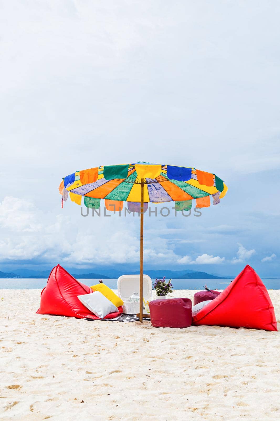 Set comfortable seats with umbrella on the beach with blue sky.