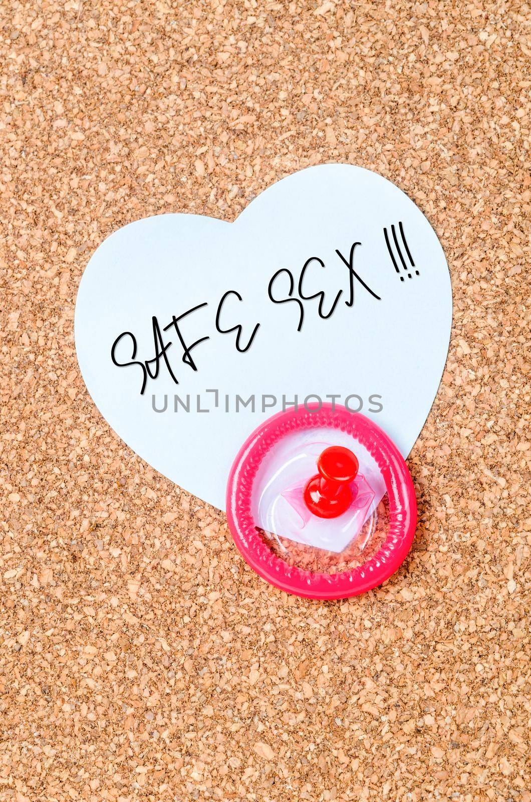 Safe sex message and condom with pin on wooden board for reminder. by Gamjai