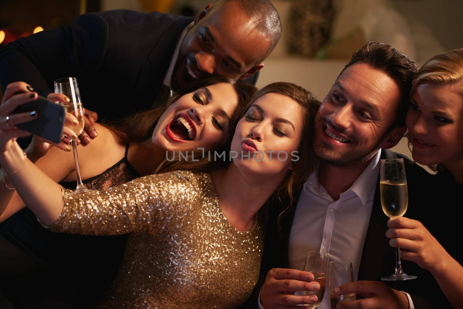Selfie, party and new year with friends in a club posing for photograph of celebration together. Champagne, toast and nightlife with a group of people taking a picture in a nightclub while dancing.