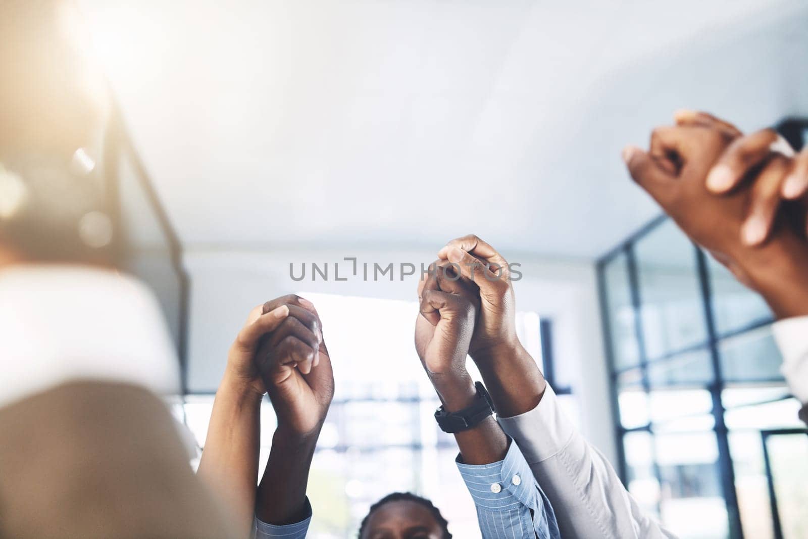 Uplifting and motivating each other to reach the top. Closeup shot of a group of businesspeople holding hands in an office. by YuriArcurs