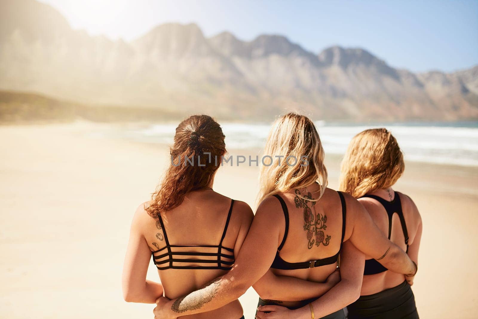 Were are the yogi sisters. Rearview shot of three young yogis standing on the beach