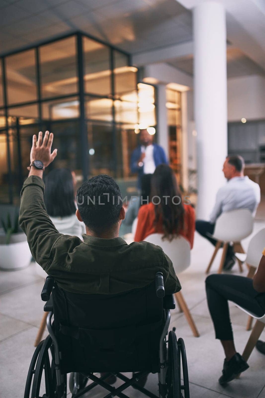 Inclusivity breaks all boundaries. an unrecognizable businessperson raising their hand to ask a question during a conference at work. by YuriArcurs