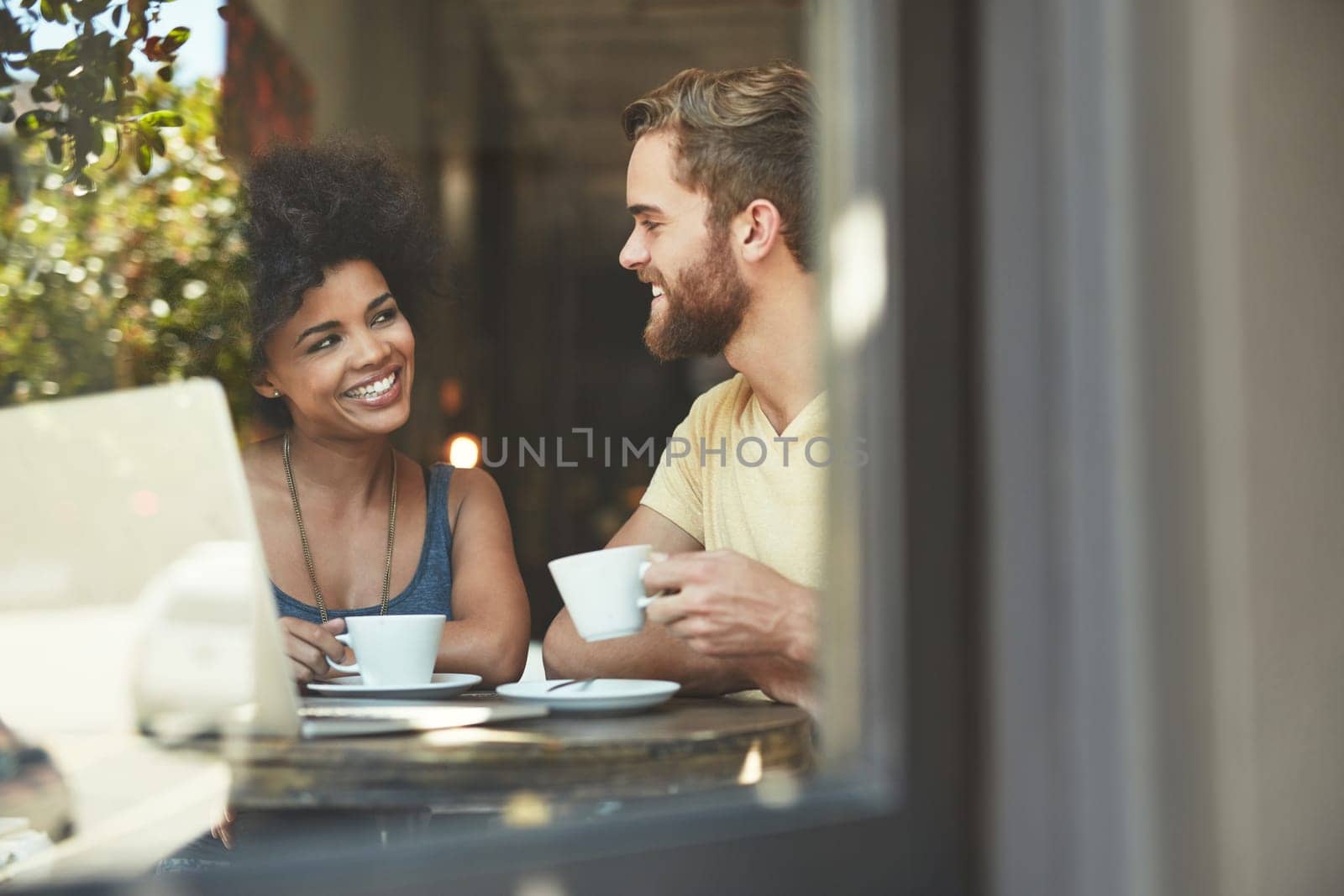 Cafe window, tea and happy people, couple of friends or customer talking, speaking and enjoy romantic date. Coffee shop conversation, communication and diversity man and woman chatting in restaurant.