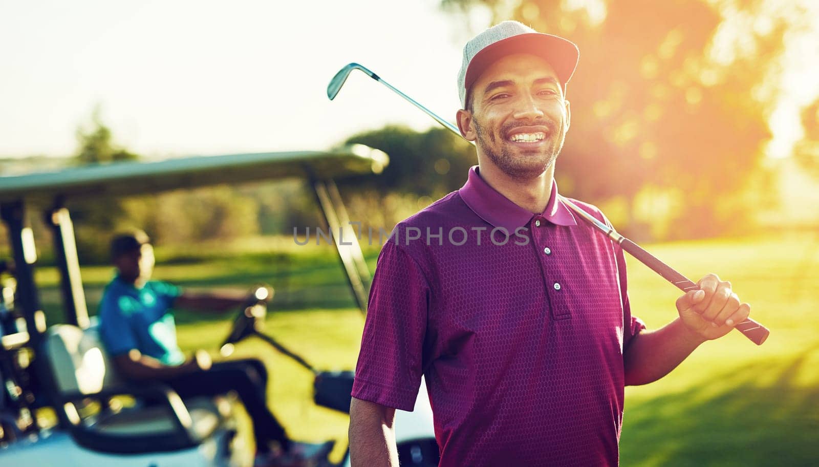Sometimes golfing is the only therapy you need. Portrait of a golfer holding his club with a buggy blurred in the background. by YuriArcurs