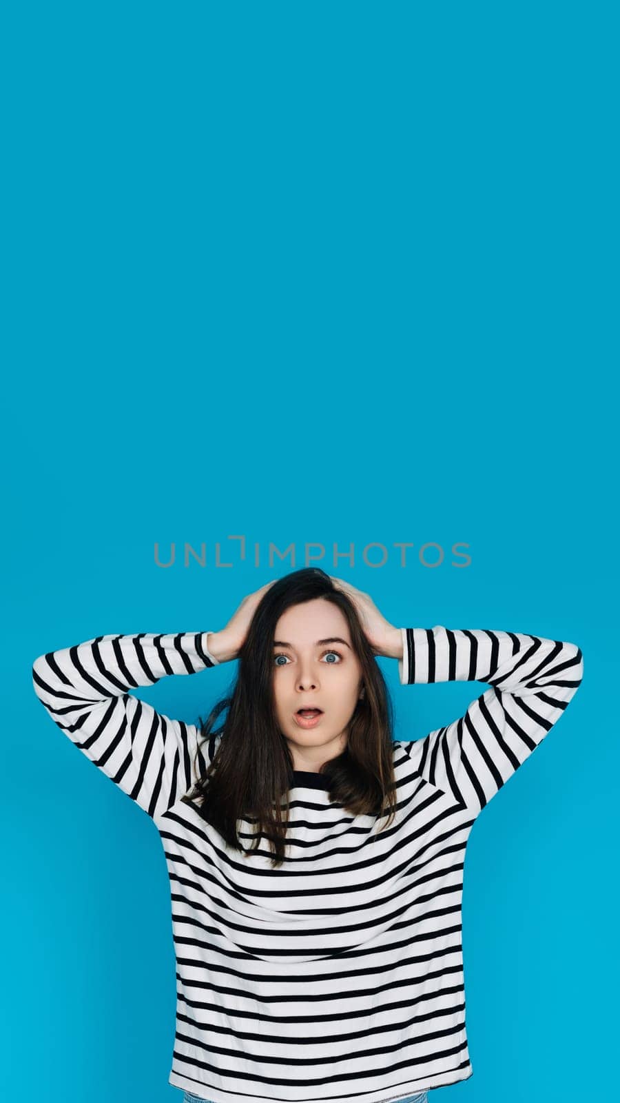 Excited Woman in Striped Sweater Celebrating Super Sale with Hands Raised, Energetic and Joyful Female Shopper Expressing Happiness - Isolated Blue Background - Perfect for Advertising and Promotions