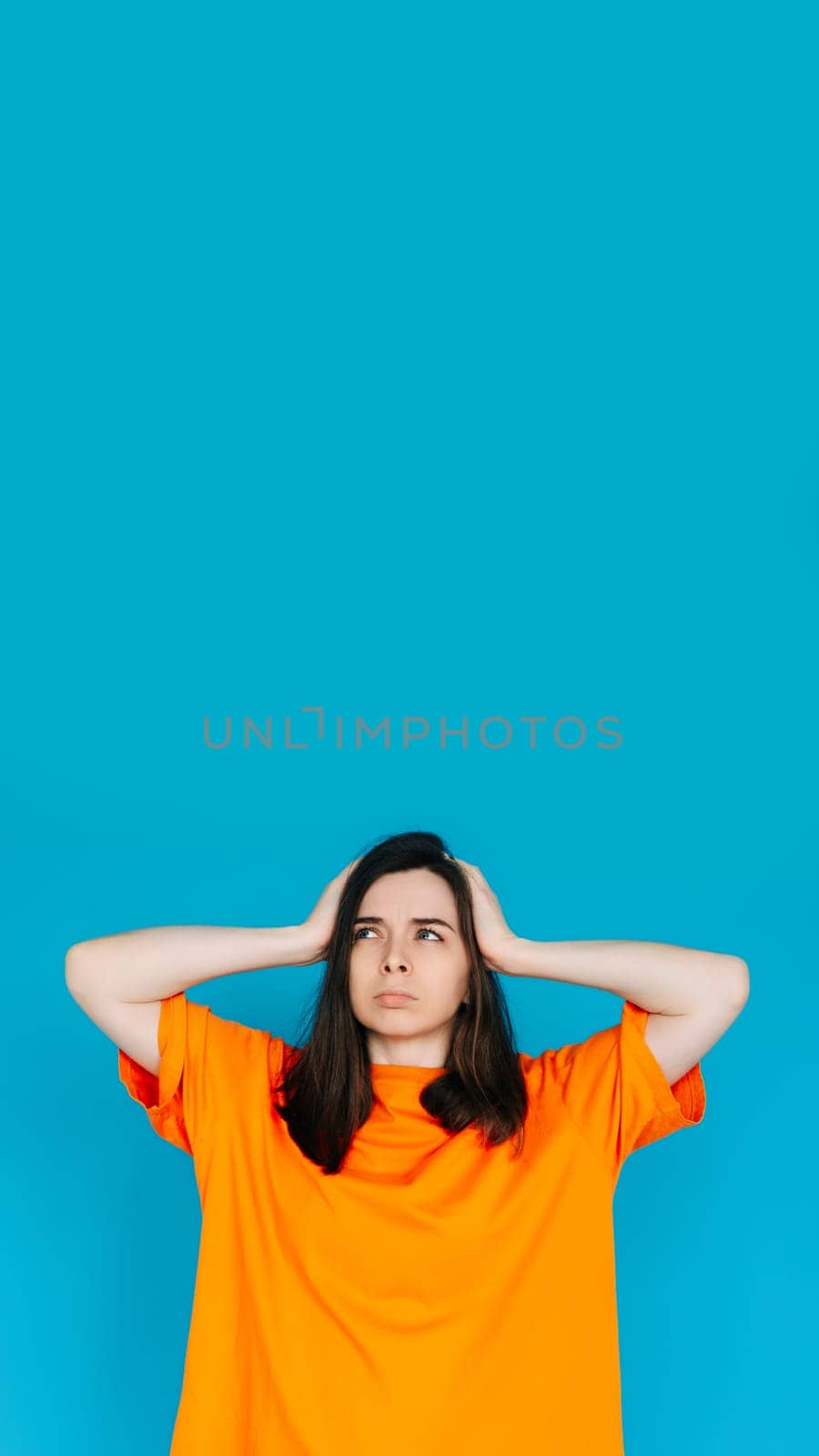 Unsatisfied Girl Touching Head, Frustration Concept - Empty Space, Disgruntled Expression, Isolated Blue Background.