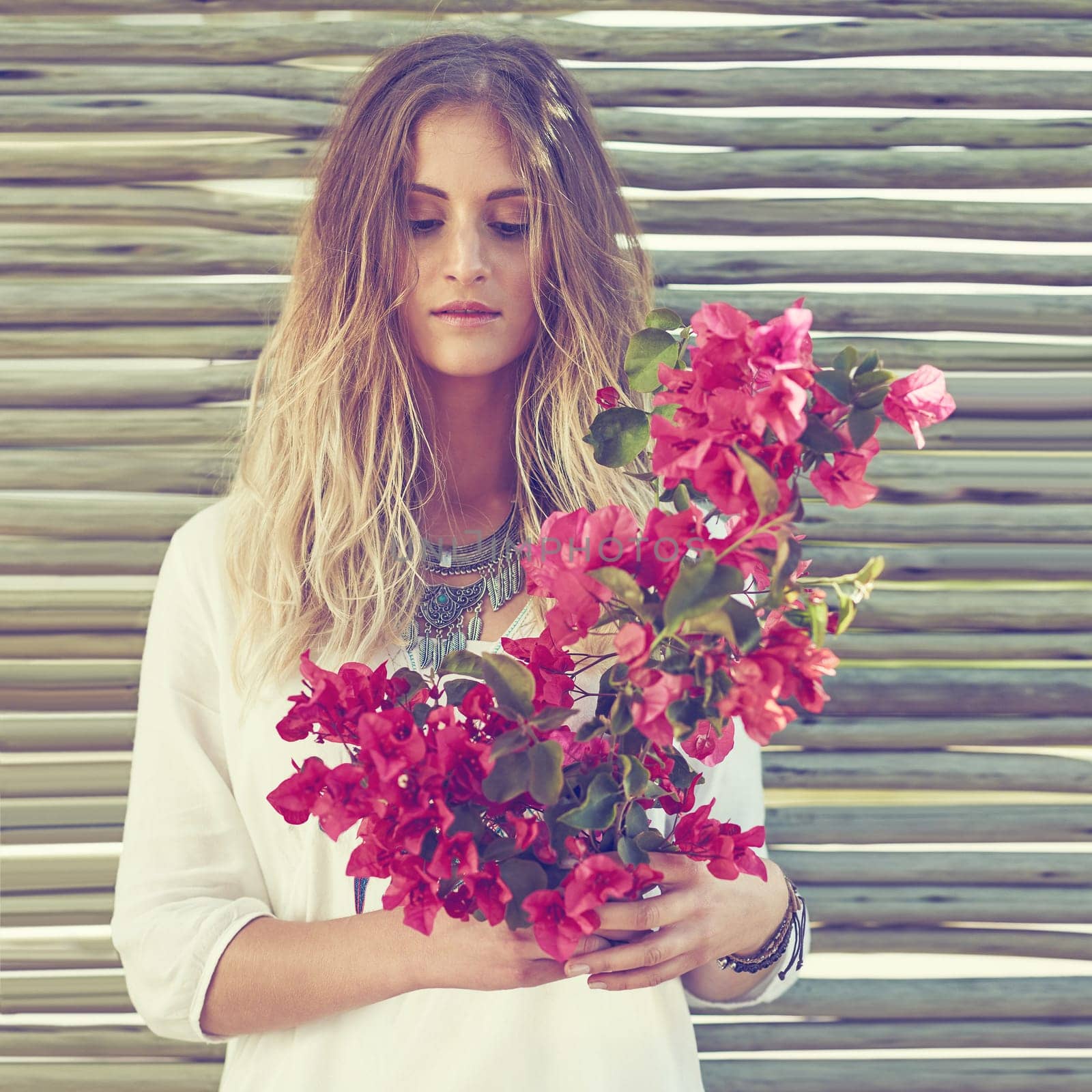 Flower child inspired fashion. an attractive young woman holding a bunch of fresh flowers