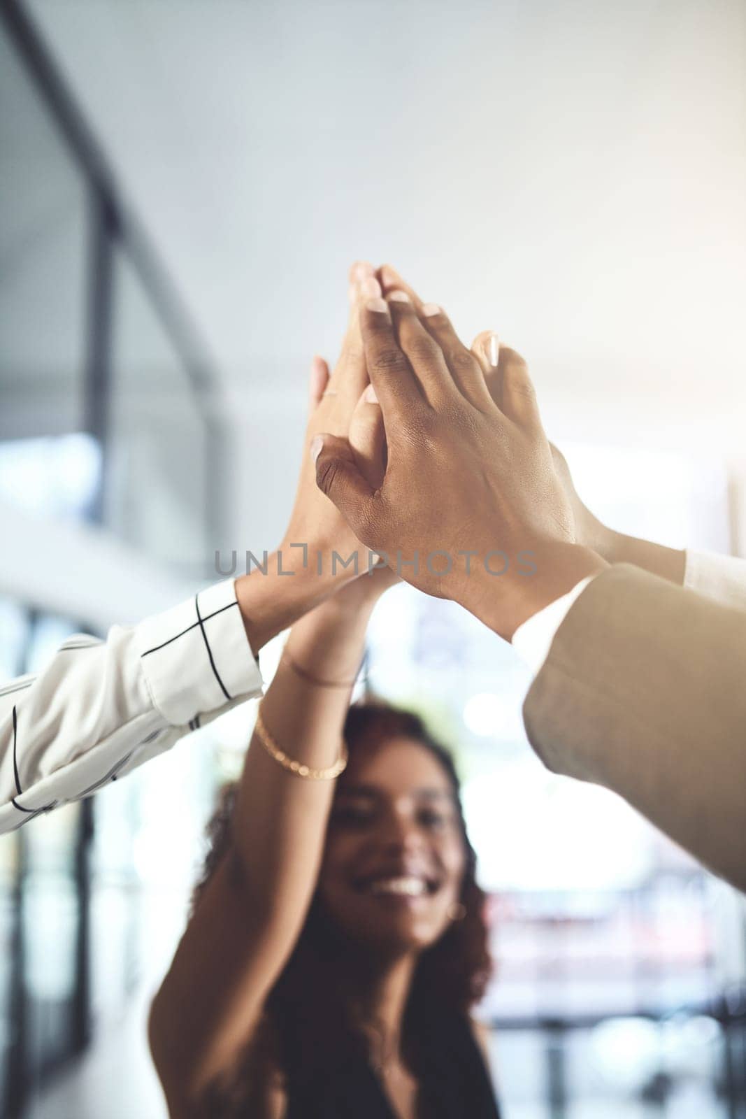 All our efforts scored us another win. Closeup shot of a group of businesspeople giving each other a high five in an office