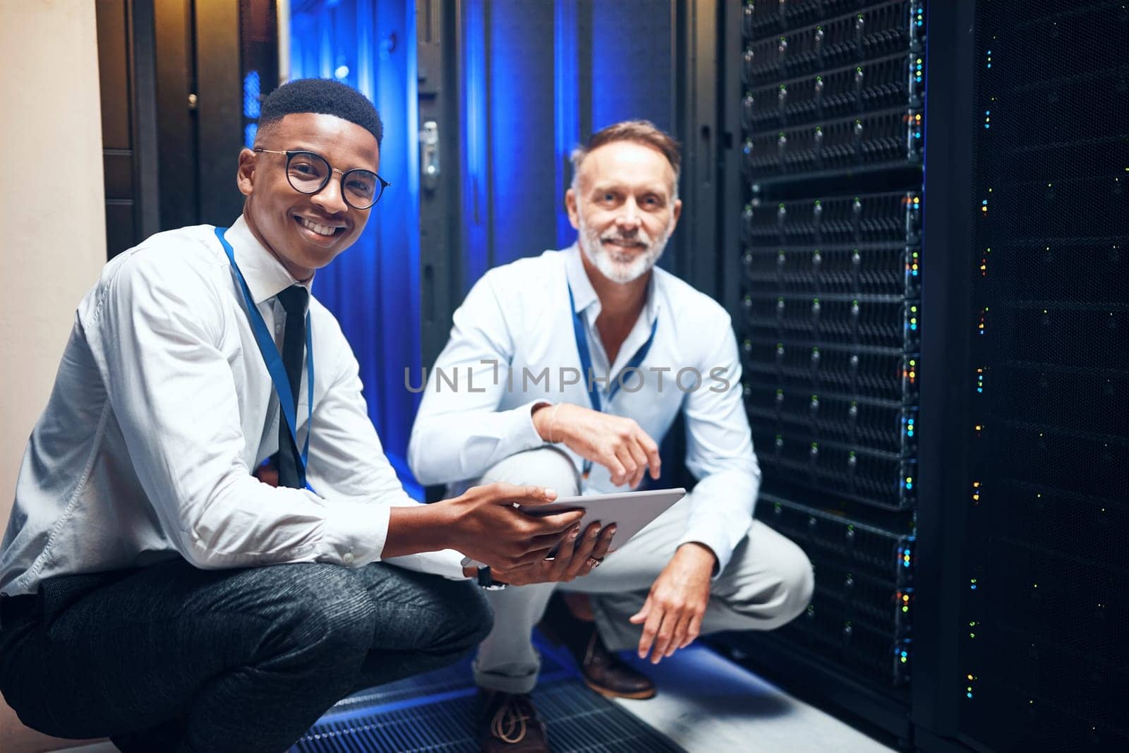 The tech gurus are on the case. Portrait of two technicians using a digital tablet while working in a server room
