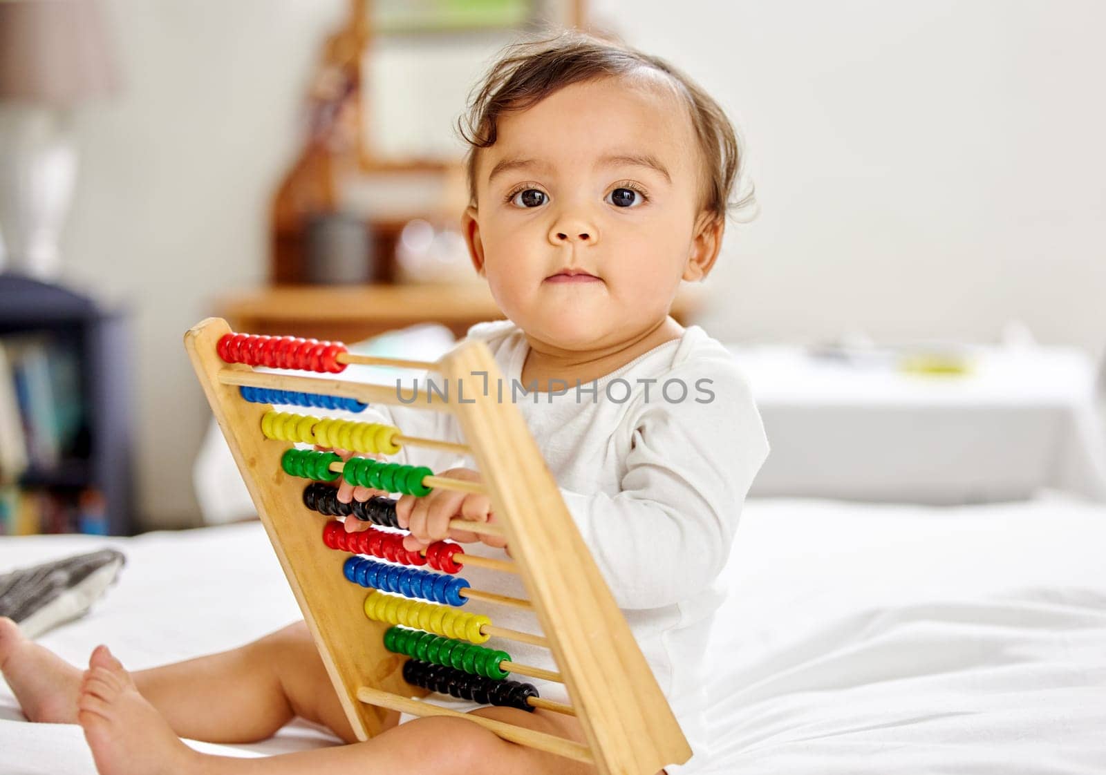 Abacus, bed and portrait of baby with toy for learning, child development and motor skills. Family home, newborn and face of adorable child with educational toys, counting beads and fun in bedroom.