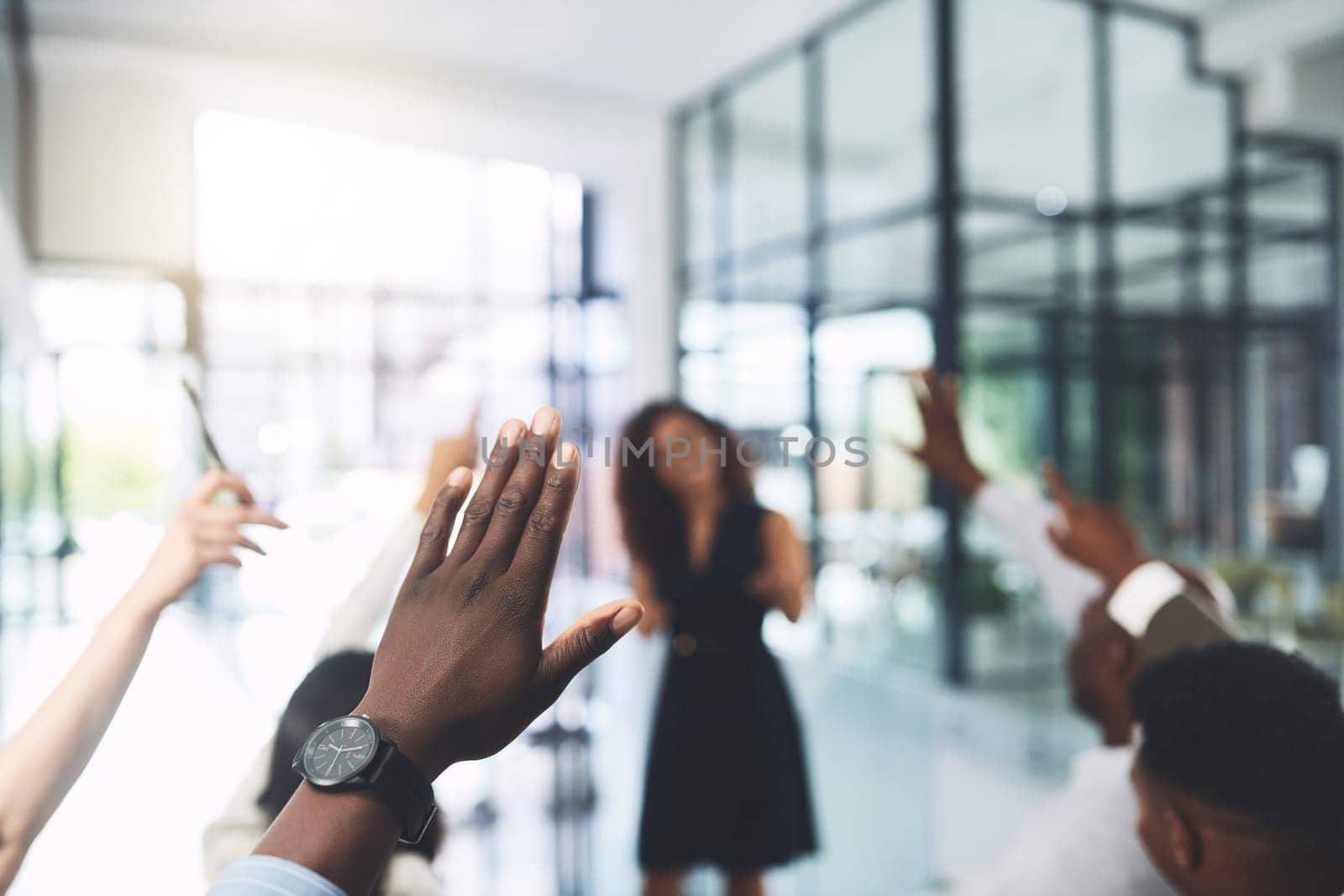 Always ask if you dont understand. Closeup shot of a group of businesspeople raising their hands during a presentation in an office. by YuriArcurs