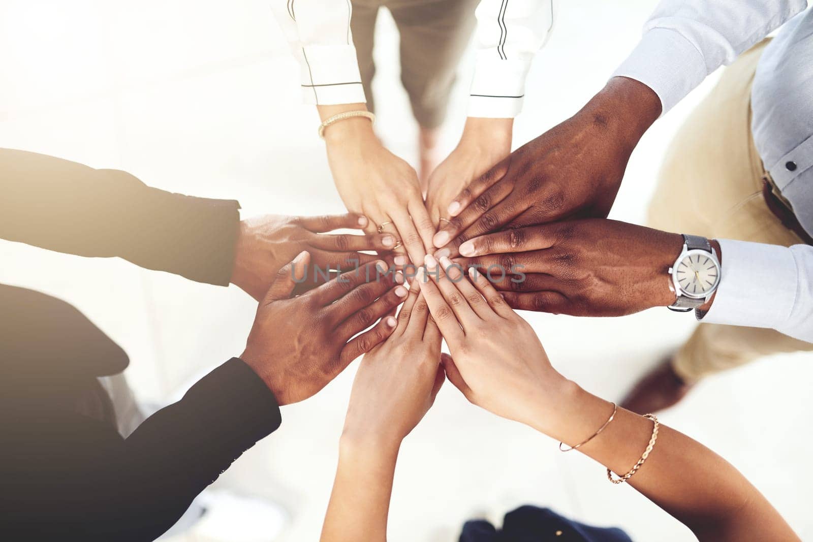 Encouraging each other to achieve greatness. Closeup shot of a group of businesspeople joining their hands together in a huddle. by YuriArcurs