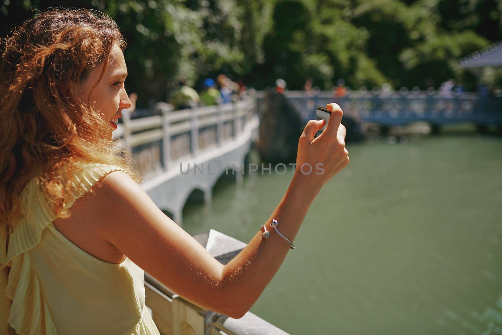 Travel fills your life with beautiful memories. a young woman taking pictures of a river in Vietnam with her smartphone