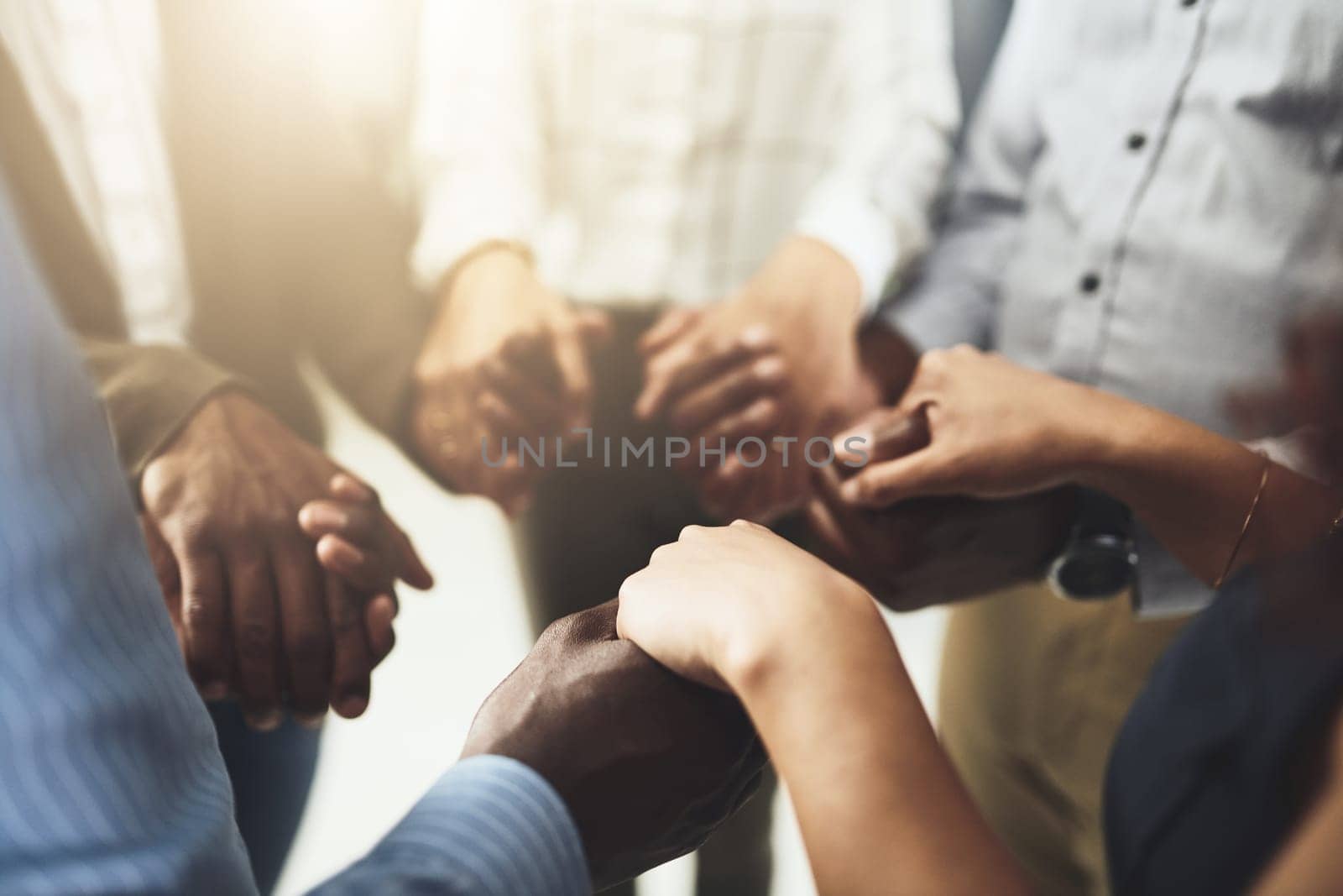 Reach out and help one another to succeed. Closeup shot of a group of businesspeople holding hands